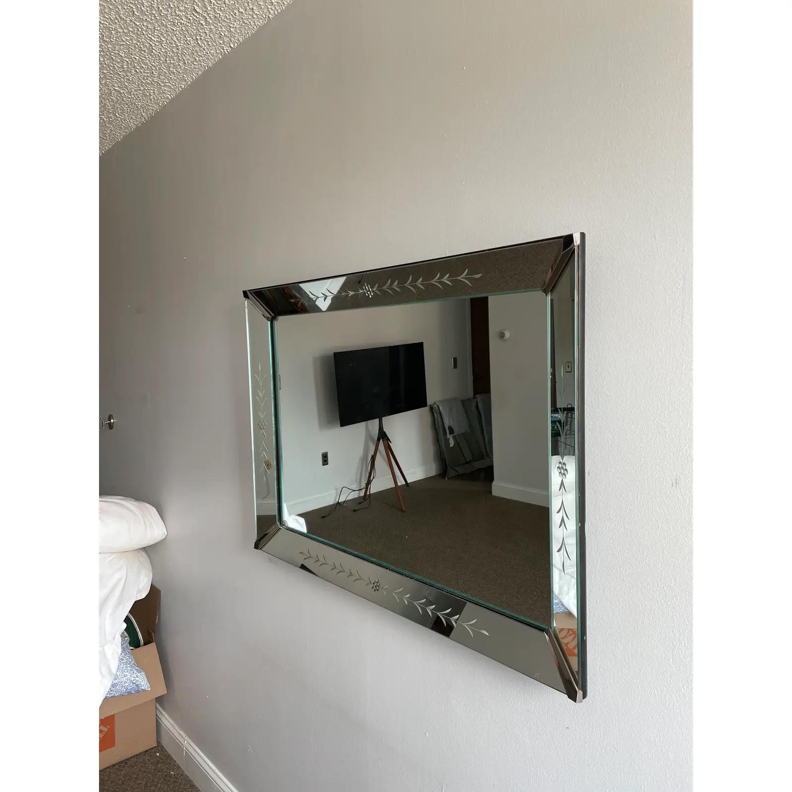 Magnifique miroir biseauté Art Déco avec de magnifiques détails gravés. Supports d'angle en métal. Livraison à domicile disponible.