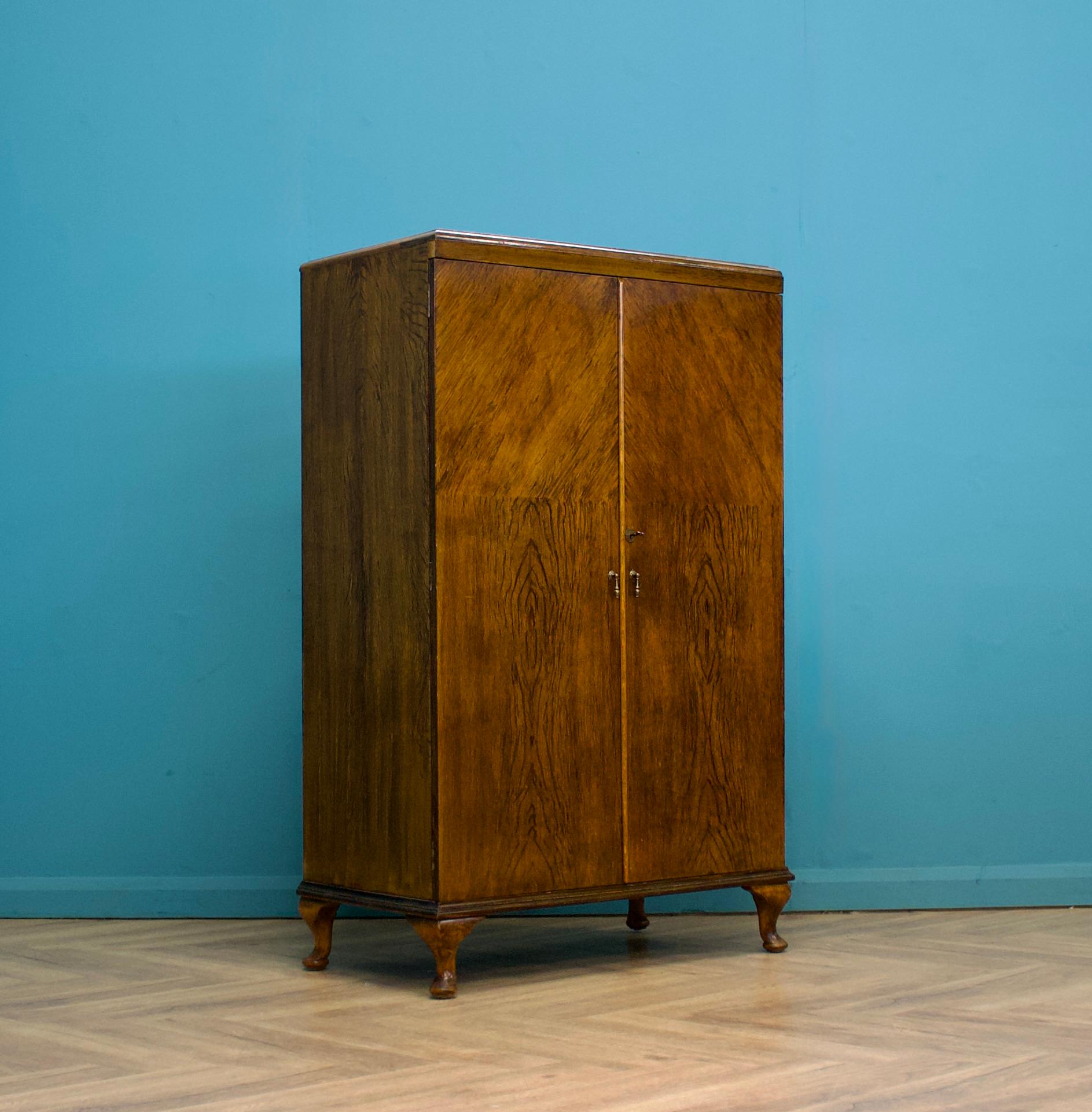 An impressive quality Art Deco burr walnut tallboy or housekeeper’s cupboard, circa 1930s


In the manner of Waring and Gillow


Standing on Queen Anne style feet


The inside has three drawers and a shelf


The original key is present and the lock