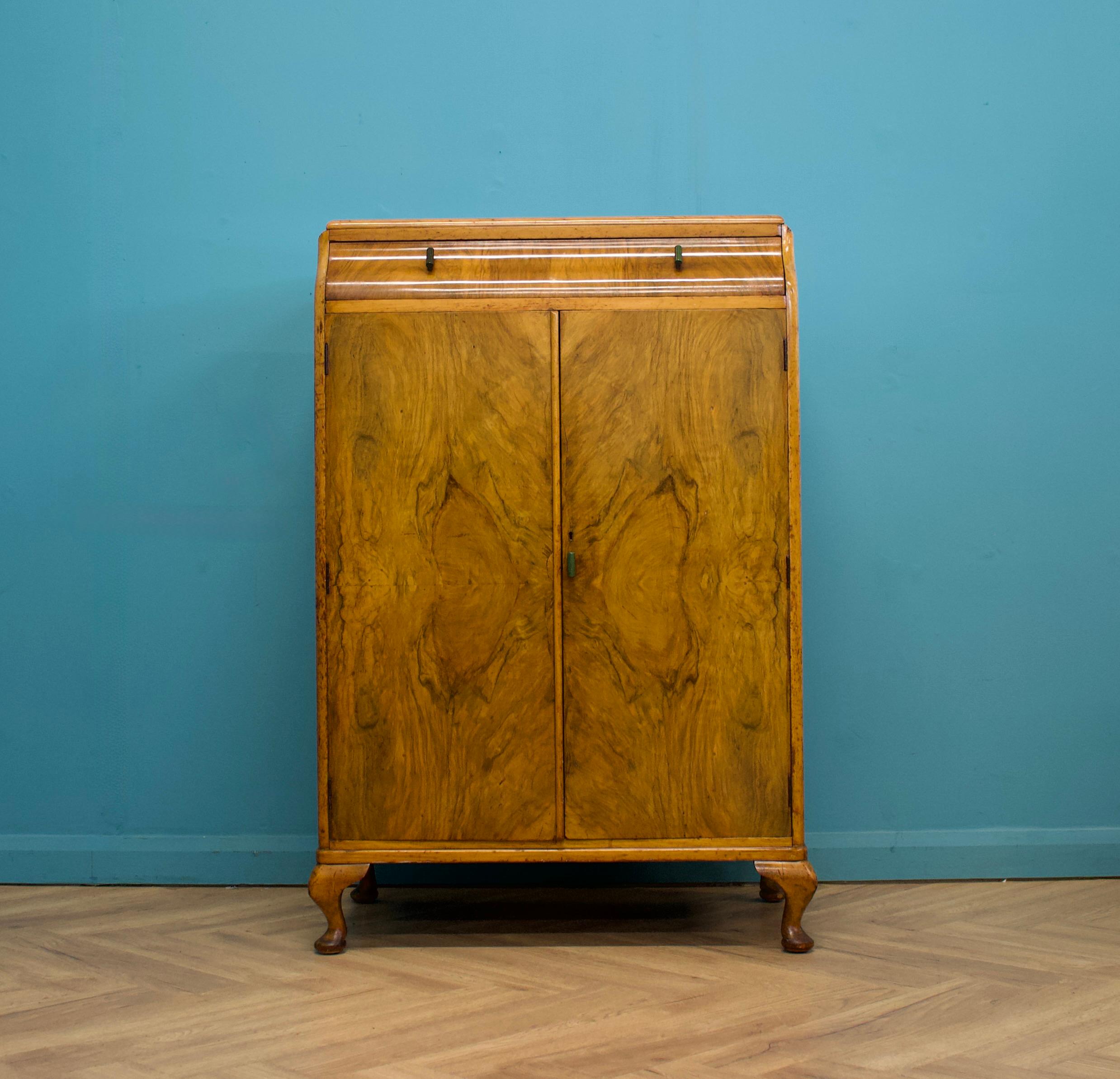 An impressive quality Art Deco burr walnut tallboy or housekeeper’s cupboard, circa 1930s


In the manner of Waring and Gillow


Standing on Queen Anne style feet


The inside has three drawers and a shelf


The original key is present and the lock