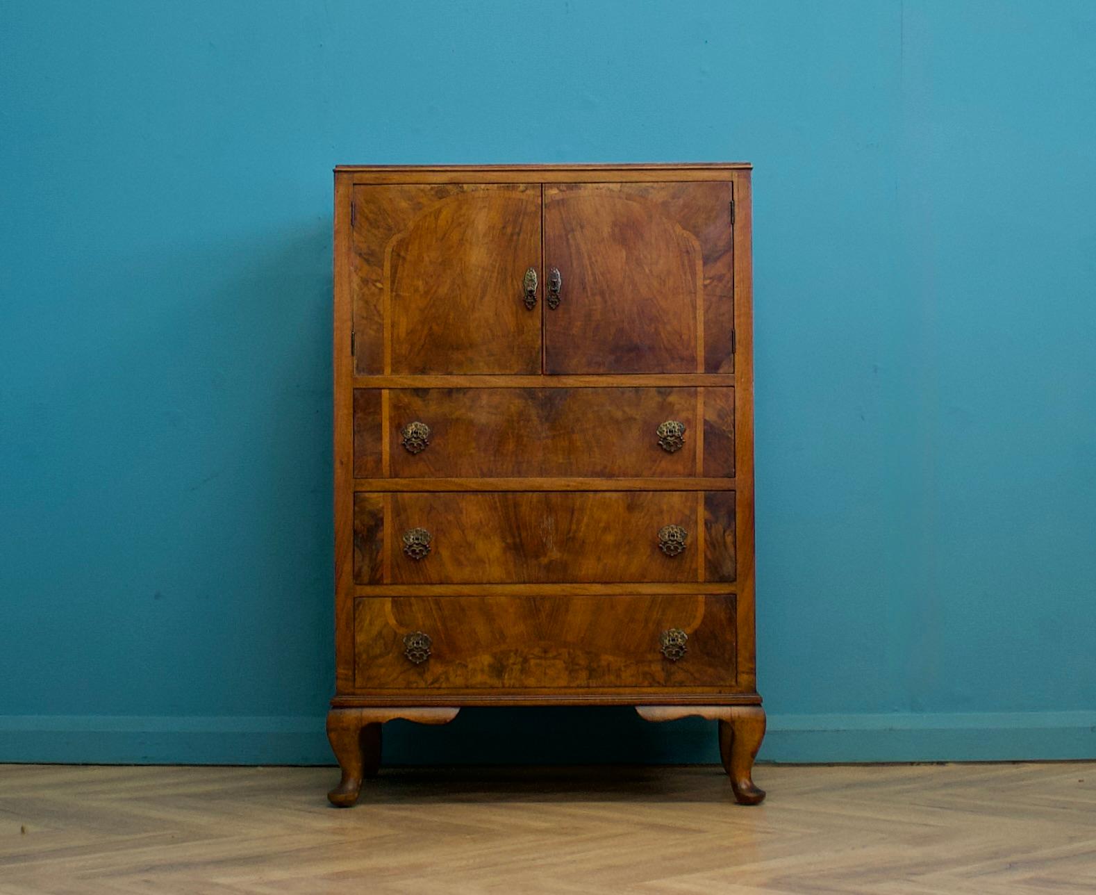 An impressive quality Art Deco burr walnut tallboy or housekeeper’s cupboard, circa 1930s

Standing on Queen Anne style feet

Featuring a cupboard to the top and three drawers

The original key is present and the lock works - the handles are made