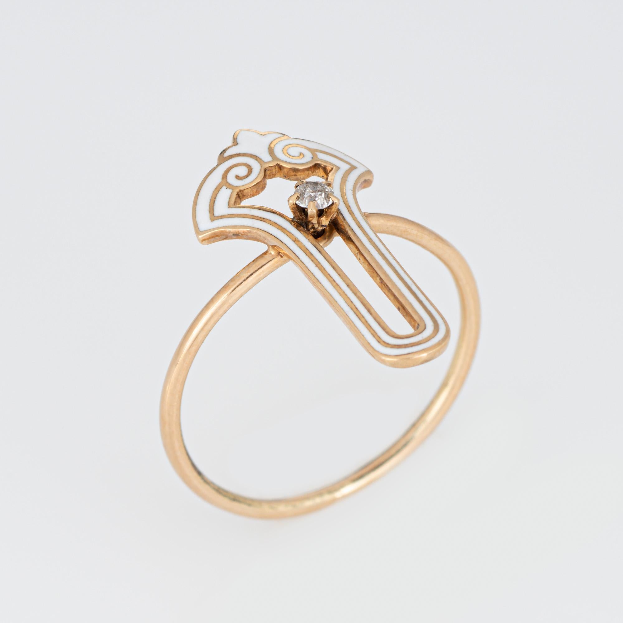 Originally an Art Deco era stick pin (circa 1920s to 1930s), the diamond & white enamel ring is crafted in 14 karat yellow gold.

The ring is mounted with the original stick pin. Our jeweler rounded the stick pin into a slim band for the finger. The