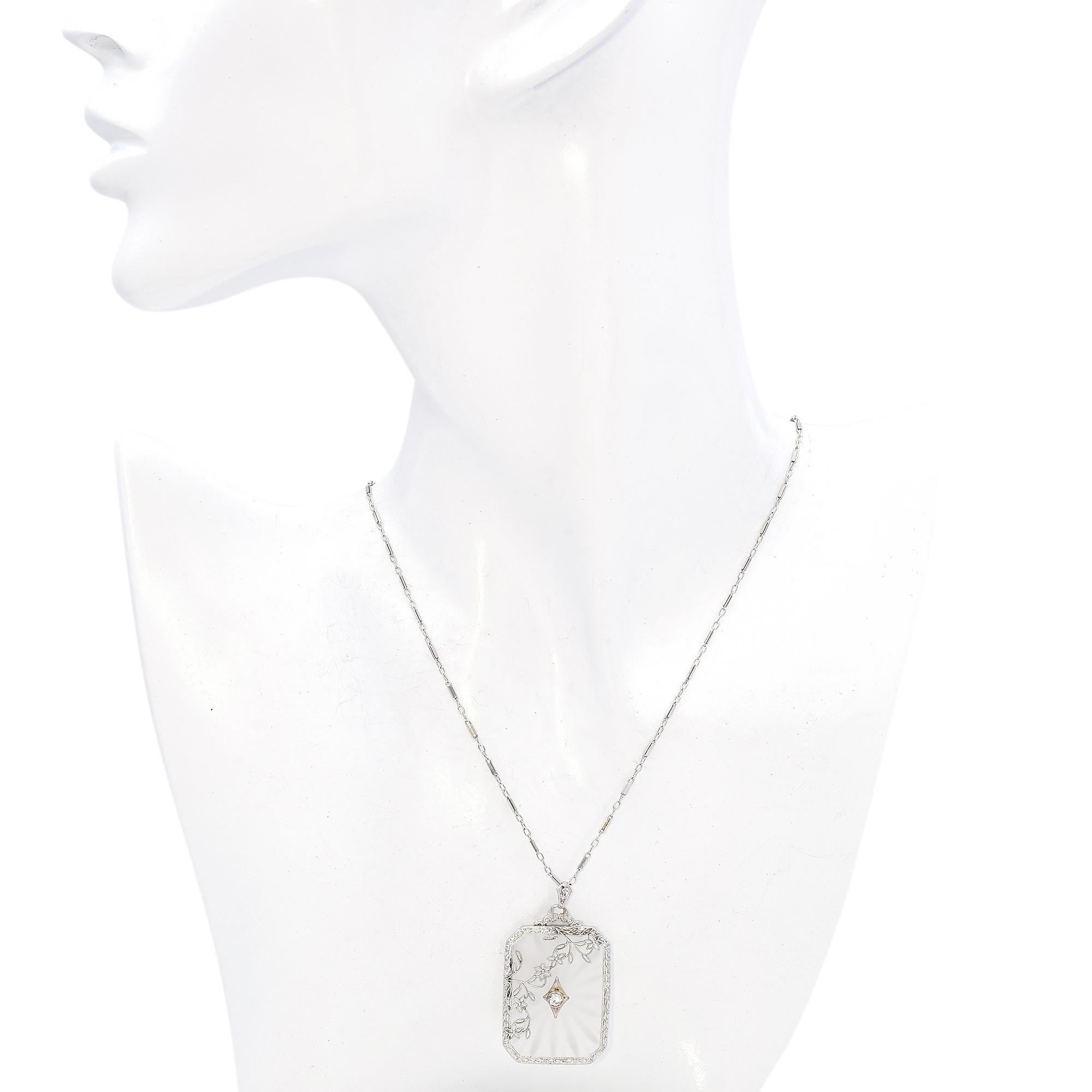 An exquisite pendant necklace featuring a round white diamond, elegantly bezel set at the center. The pendant showcases intricate floral filigree detailing, accentuating its Art Deco charm.

Weight: 8.8 Grams
Stone: Diamond (3 mm, 0.11