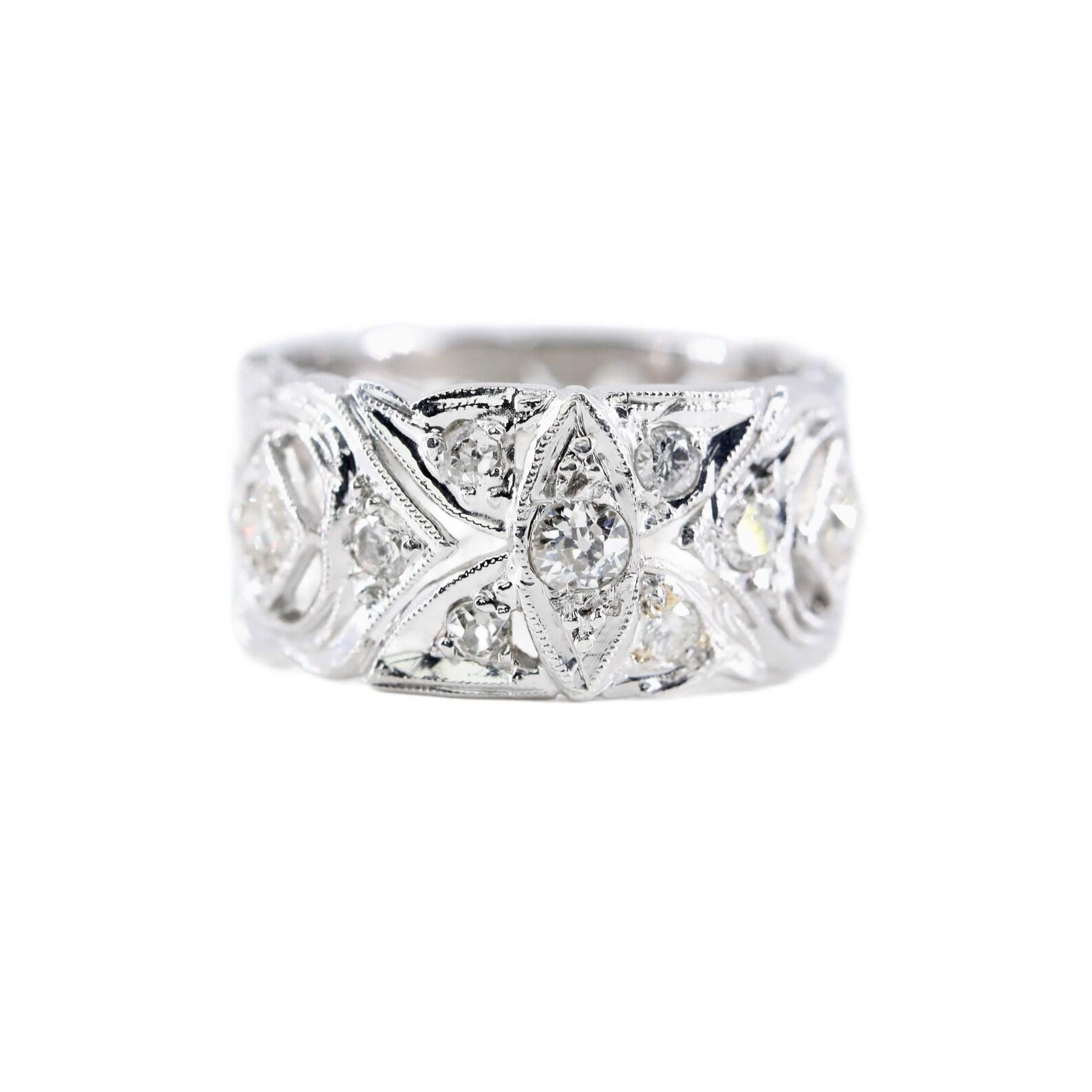 A wide diamond eternity band ring in platinum. Set throughout with 1.10ctw of old European cut diamonds of H color, VS to SI clarity. Accented by miligrain beading, and hand pierced filigree work in a traditional Art Deco manner.

Ring tests as
