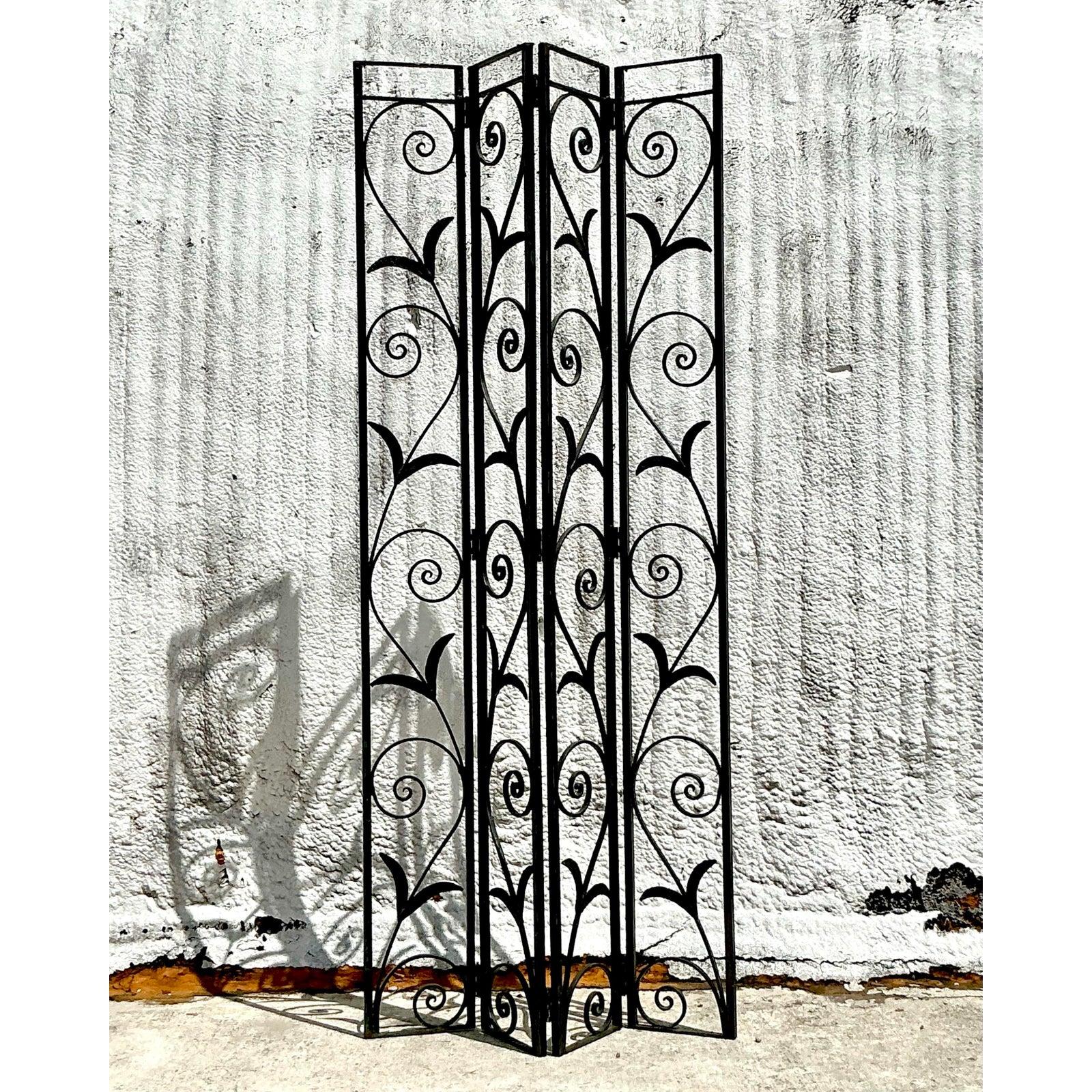 Striking in form and craftsmanship, this Vintage Art Deco Wrought Iron Screen brings architectural elegance and timeless flair to any space. Featuring hand-forged iron scrollwork with a botanical motif, this four-panel folding screen is both