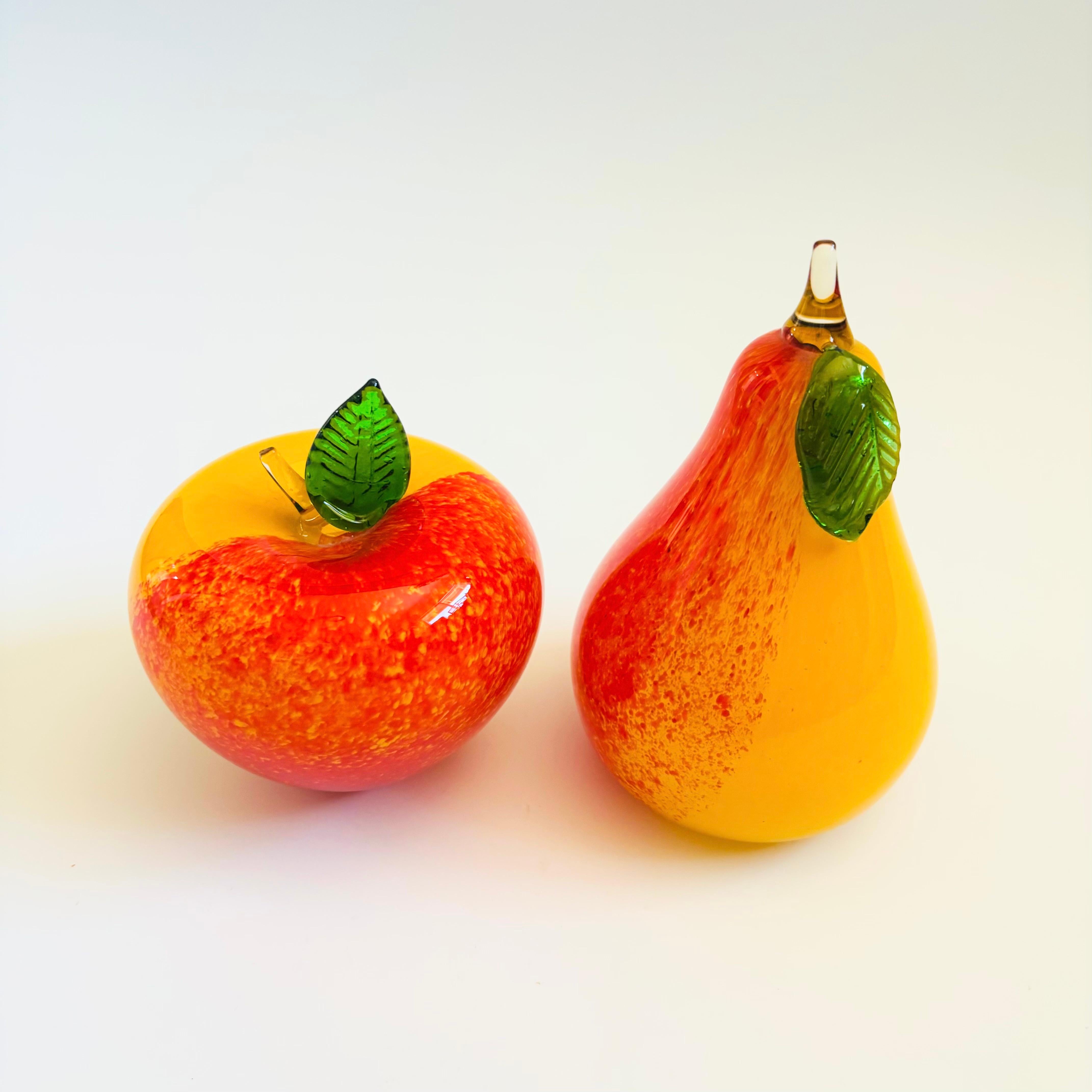 Una coppia di frutti in vetro artistico vintage a forma di mela e pera. Il vetro è colorato di giallo e arancione con foglie verdi. 
Misure:
Mela: 4 