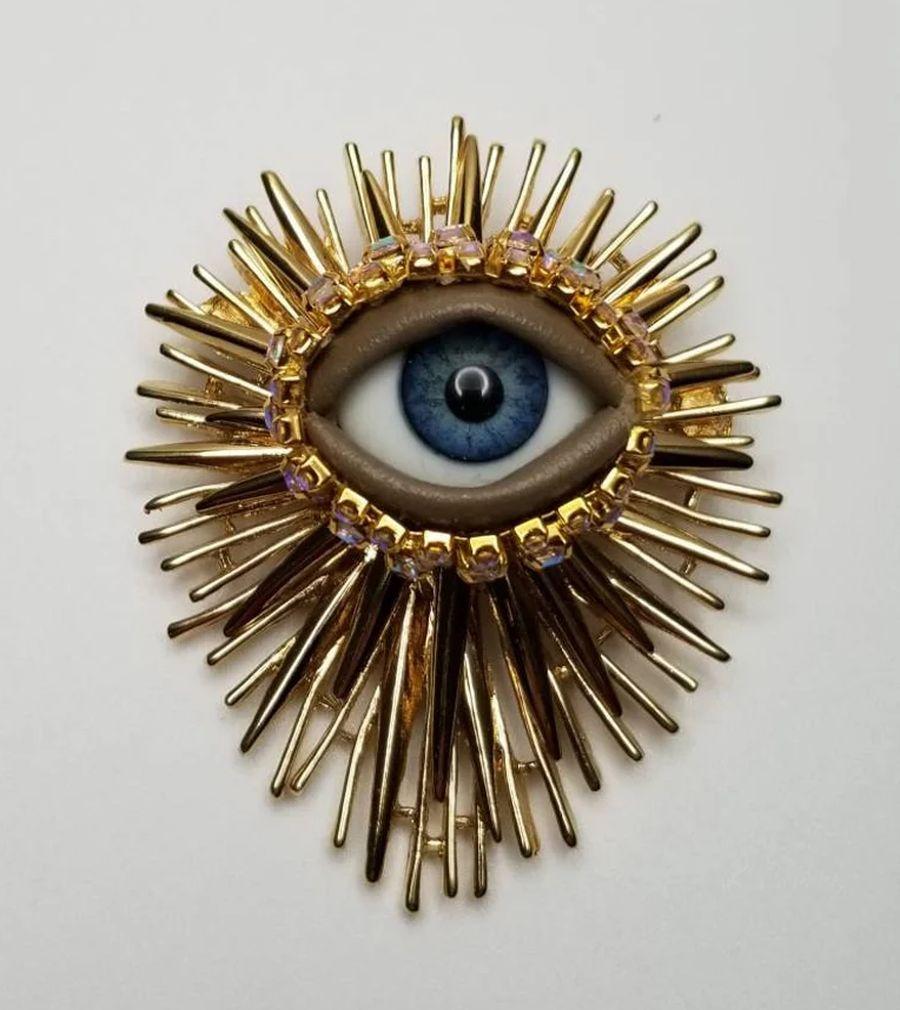 Simply Beautiful! Vintage Mid Century Modern Art Glass Evil Eye Golden Statement Brooch Pin. Centering an Art Glass Evil Eye surrounded by Crystals. Hand set in Striking Spiky Gold tone Hand crafted mounting. Evil eye protection piece. More
