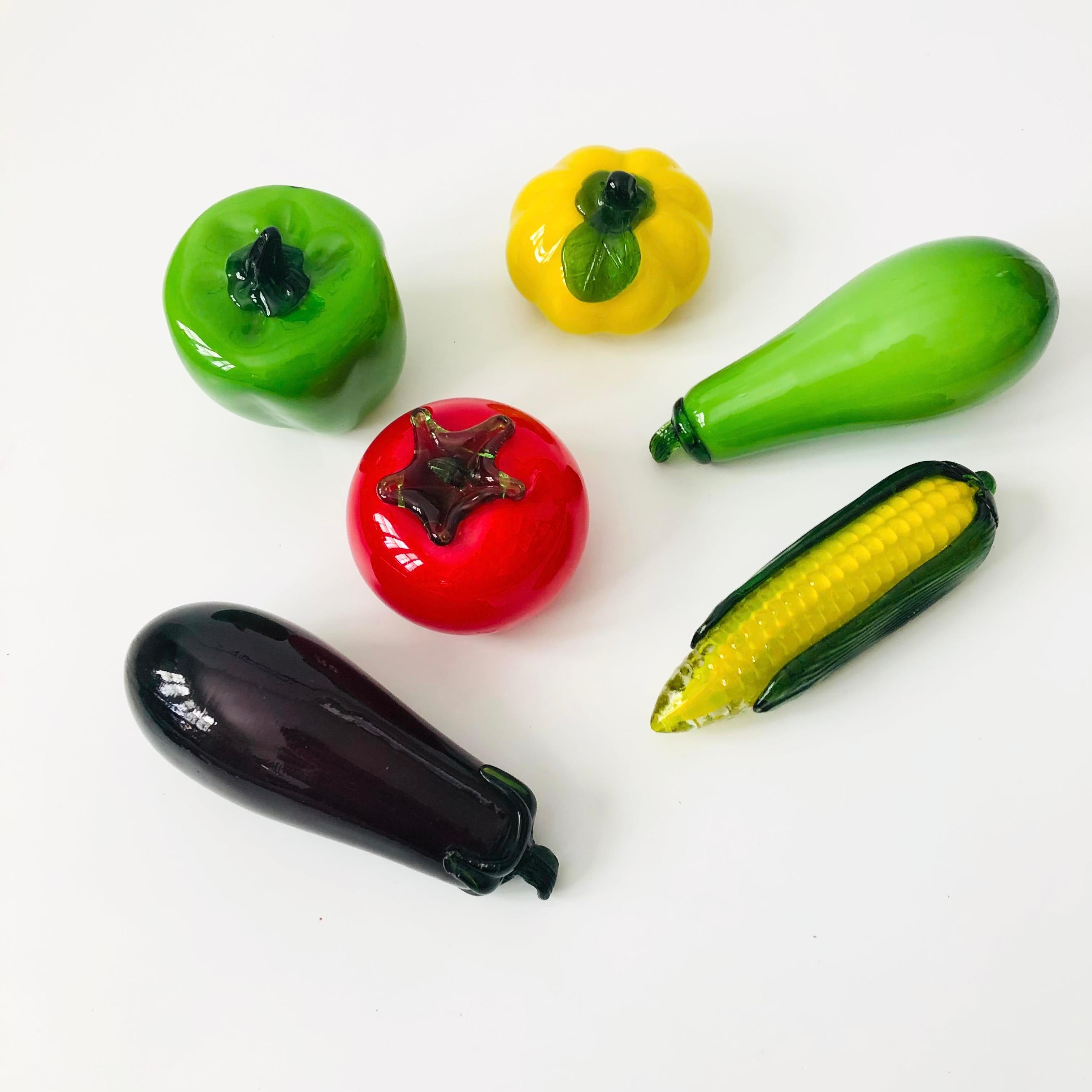 A set of 6 blown art glass vegetables. Vibrant colors to the glass and realistic detailing. The set includes an eggplant, ear of corn, bell pepper, tomato, yellow squash, and a green squash.
Please see pictures for dimensions.