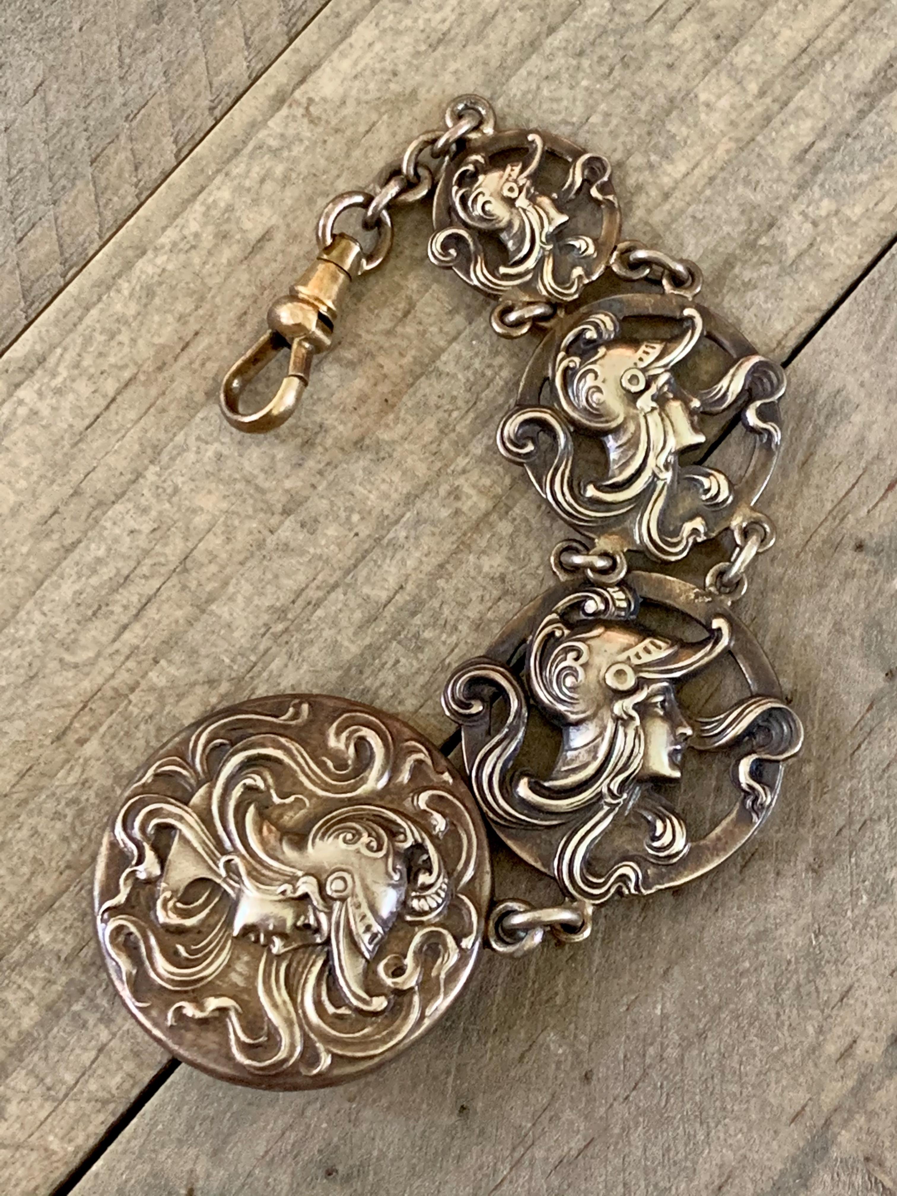 This vintage Art Nouveau watch fob features four Sterling Silver panels which each have a relief of a soldier's head.  

There is no stamp.

Fob length measures approximately 6