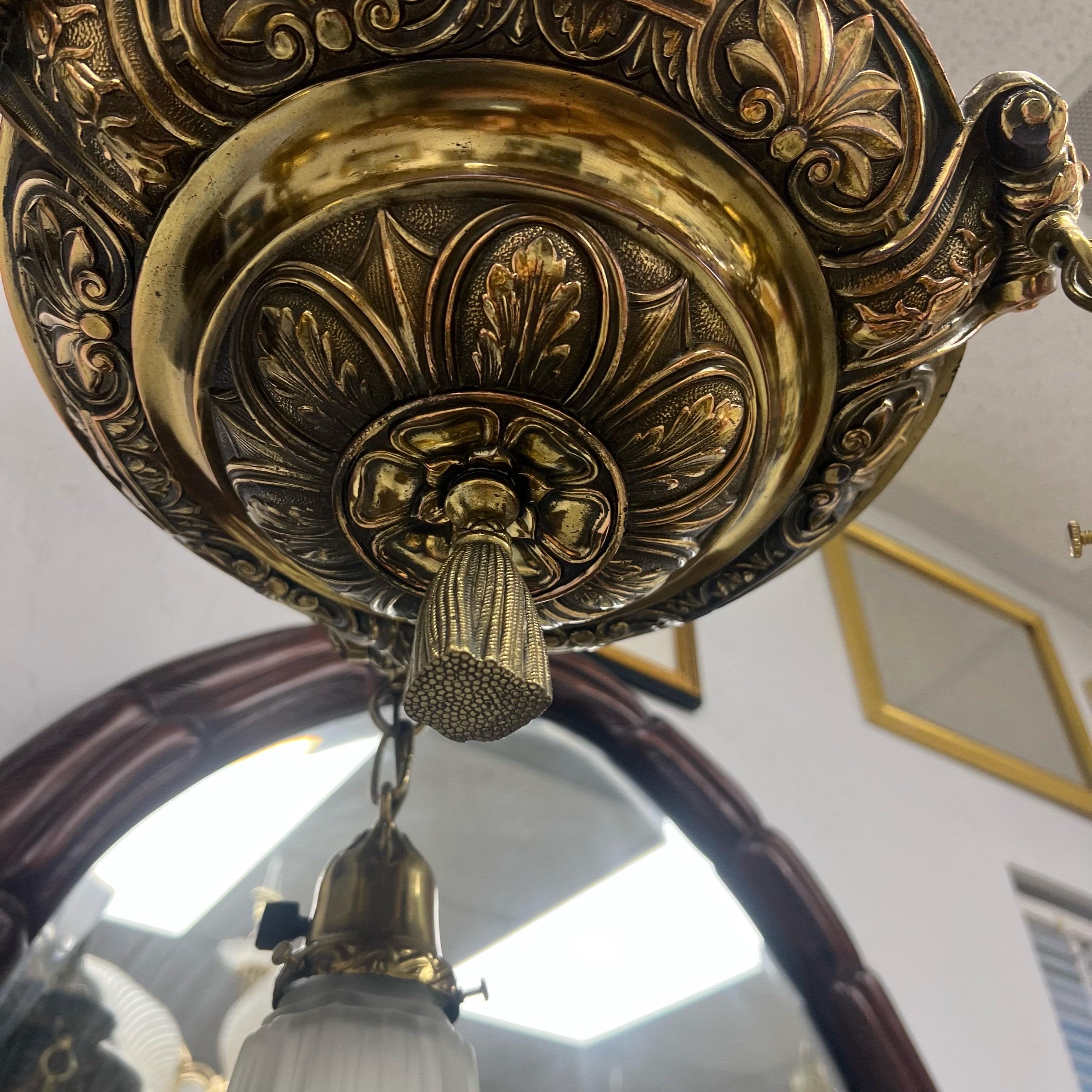 Newly rewired and ready to hang, this overly ornate bronze and brass chandeliers has 3 lights that you can turn on individually or hardwire them to a switch.  The fluted satin glass shades are perfectly paired with the brass tassel hanging from the