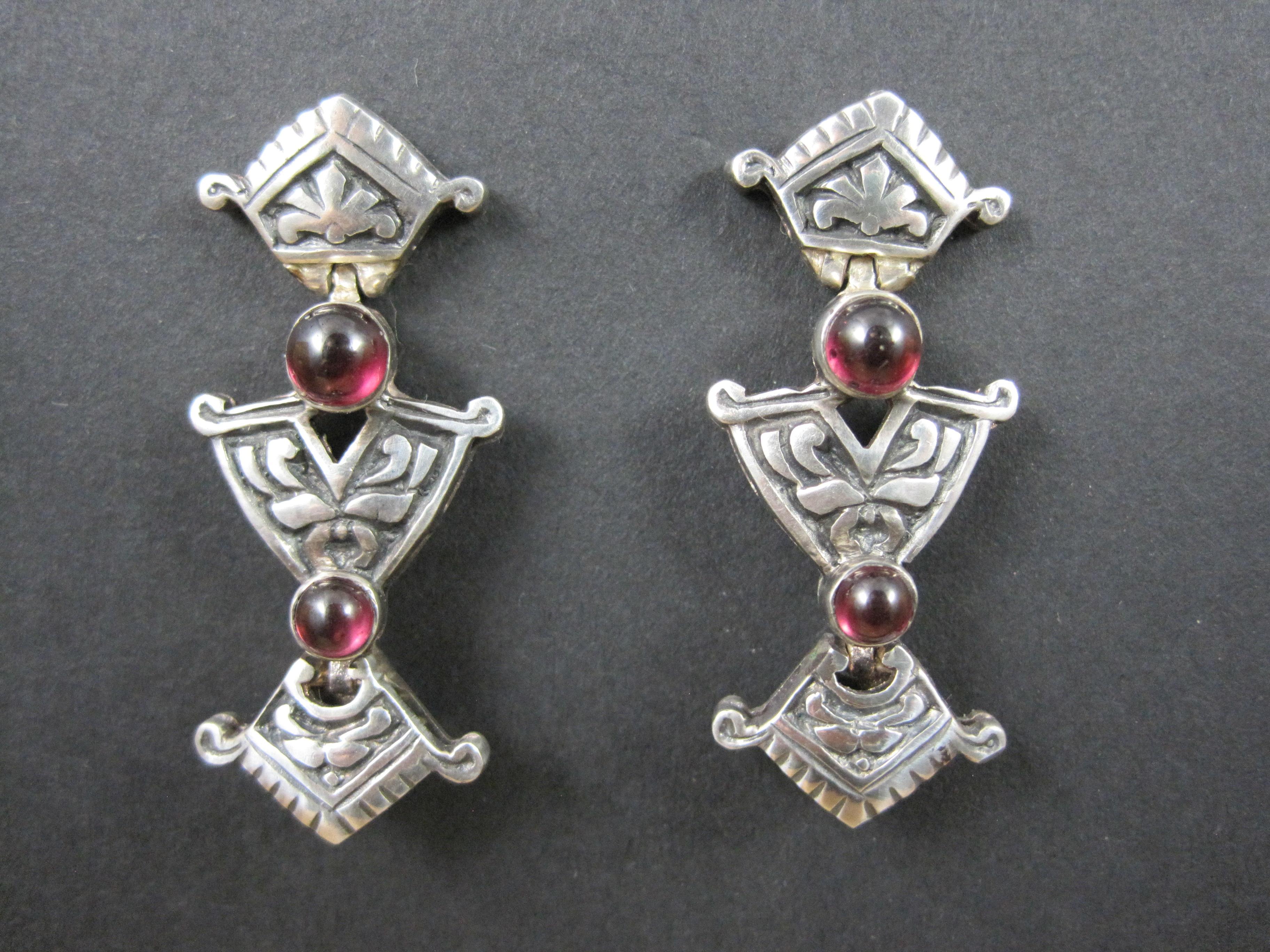 These gorgeous vintage earrings are sterling silver.
They have an art nouveau style to them with natural garnet cabochons.

Measurements: 5/8 by 1 1/2 inches
Weight: 9.9 grams

Condition: Excellent with minor patina

These earrings have been steam