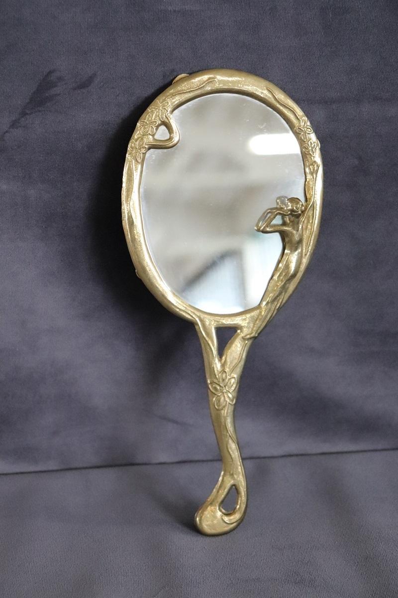 Beautiful refined women's hand mirror. In perfect Art Nouveau style made around 1980s. The frame is in finely chiselled golden brass with the profile of a woman on the side. Perfect conditions.