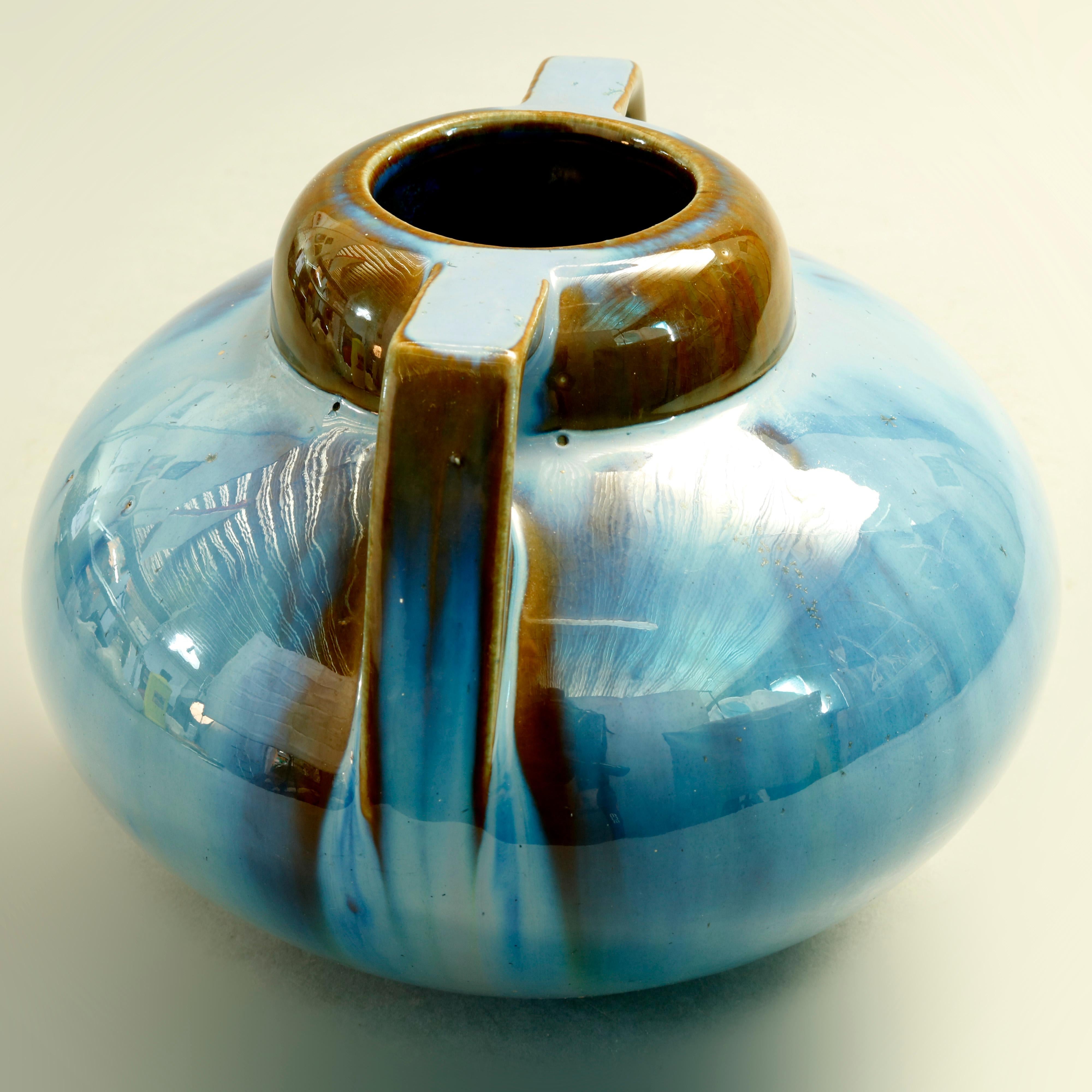 A vintage vase by Fulper offers gourd form with double handles and mirrored blue drip glaze finish, marked n base as photographed, 20th century

Measures: 5.75