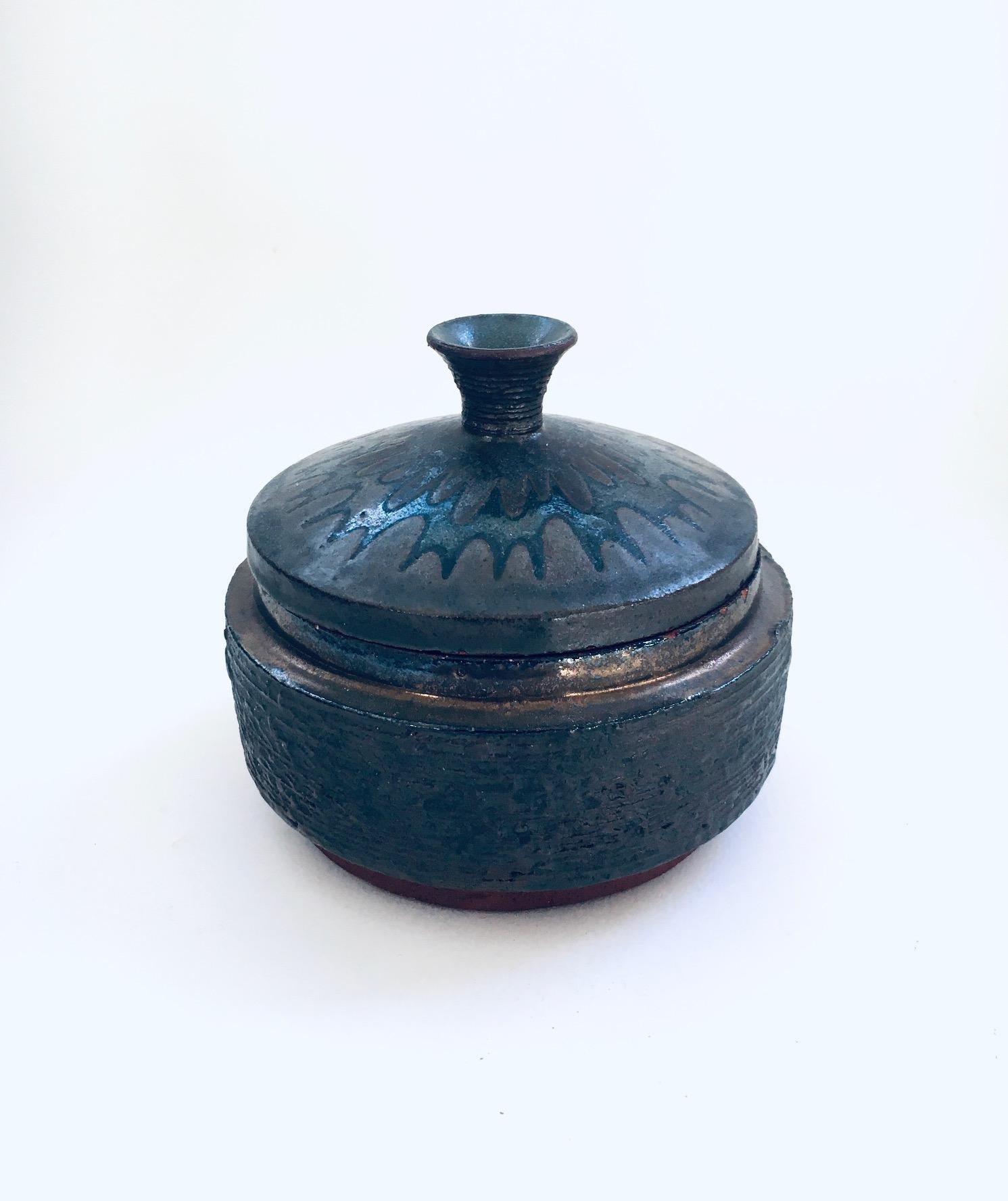Vintage Midcentury Art Pottery Studio Lidded Bowl by Amphora, Perignem Studio, Belgium 1960's. Probably by Rogier Vandeweghe. Stamped on the bottom. Nice dark glazed outside with typical relief on the bowl and figurative on the lid, cream glaze on