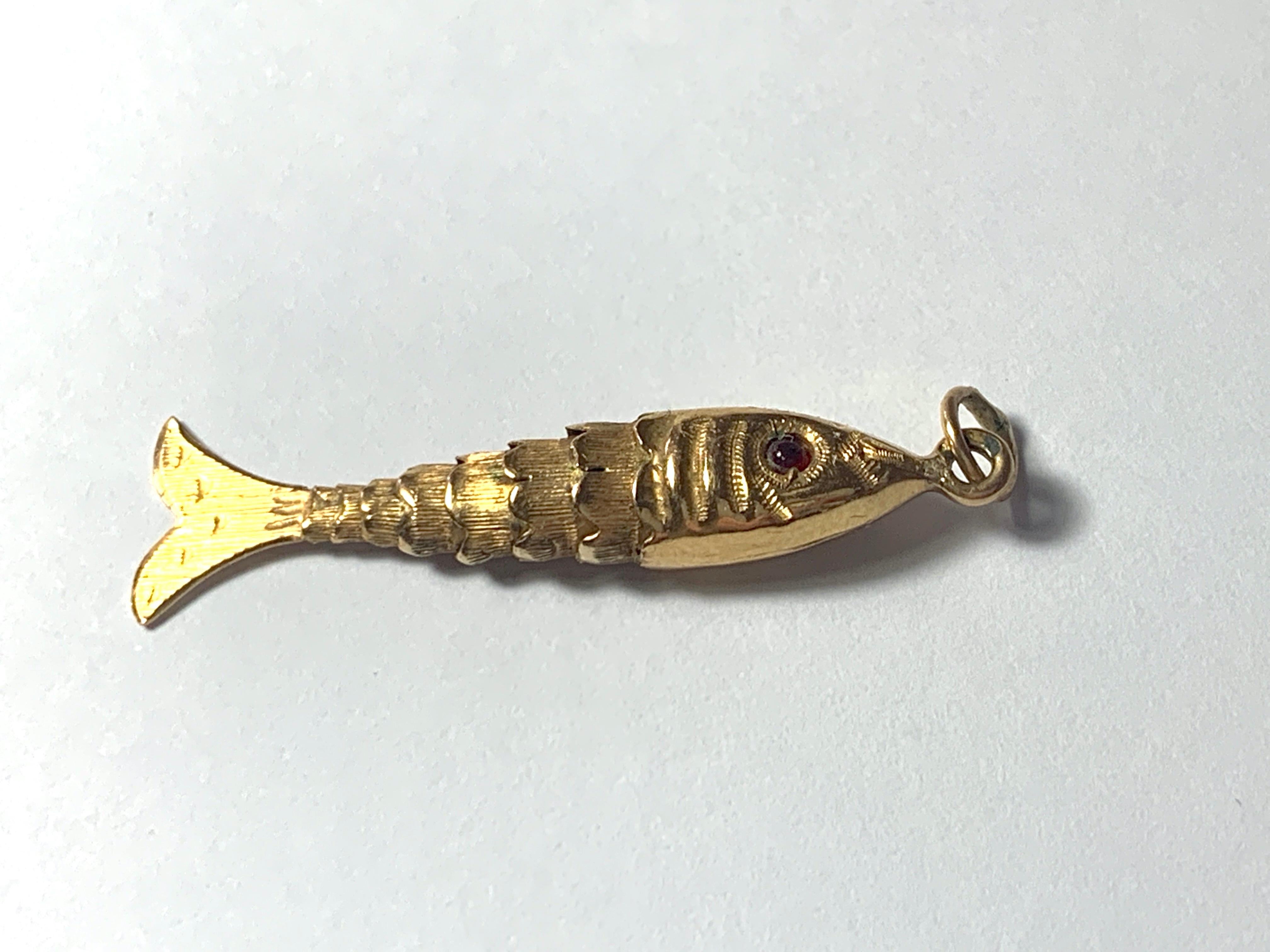 Beautiful Vintage Articulated 19ct Gold Fish Pendant 
Each segment is beautifully hand etched 
with red gem stone eyes.
Portuguese stamp marks to the bail
Circa 1940