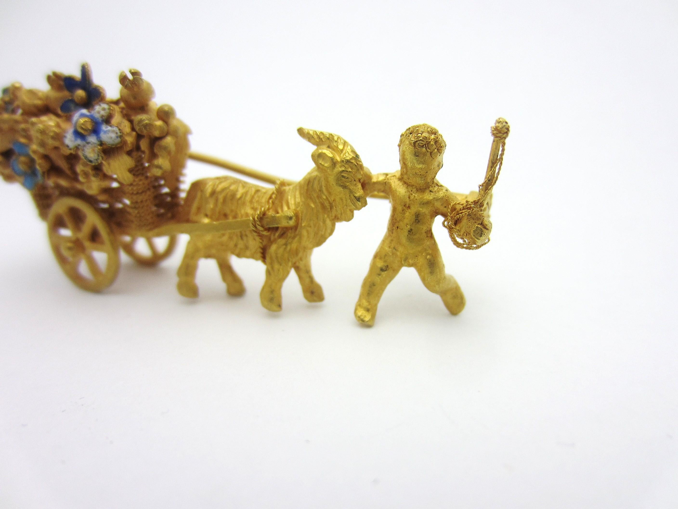 This vintage brooch is a detailed piece of history.

Made in 18k bloomed bright yellow gold, this brooch depicts a cart with articulated wheels and a basket-weave texture carrying a load of blue, green, and white enamel flowers.  A cherubic child
