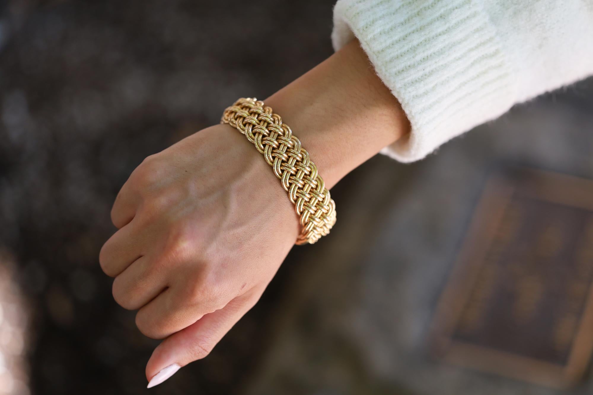This unique and bespoke cuff bracelet is a substantial estate heirloom weighing over 2 ounces. The high luster bangle was hand woven from only 2 strands of 14k yellow gold, laced in a lovely French braid. Versatile enough to wear in a stack or
