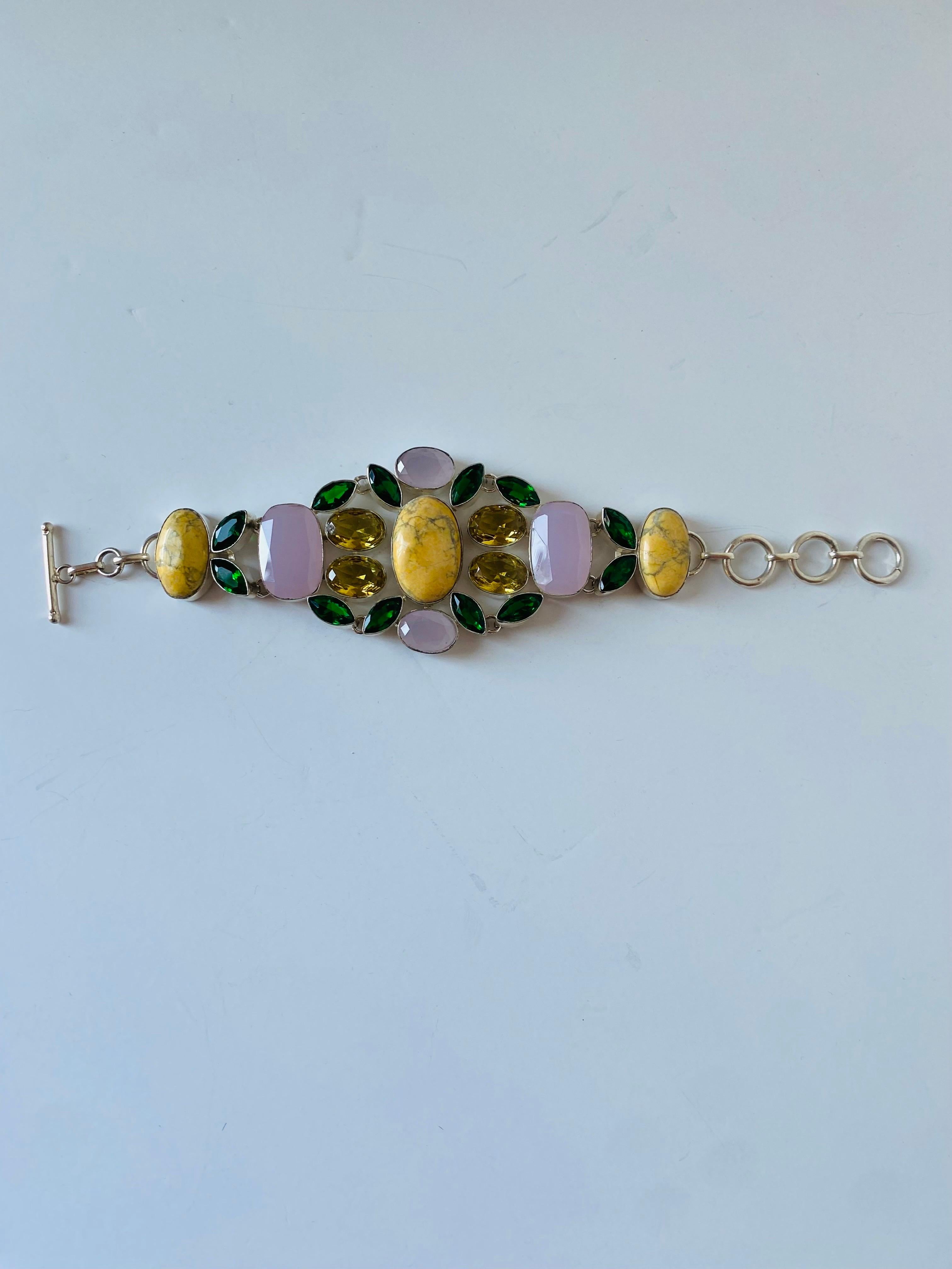 Bellissimo bracciale scultoreo in pietra semipreziosa realizzato a mano con struttura in argento sterling.  Questo pezzo è glamour e chic.  Le pietre verdi accentuano le forme, mentre le pietre preziose gialle aggiungono splendore e fascino alle