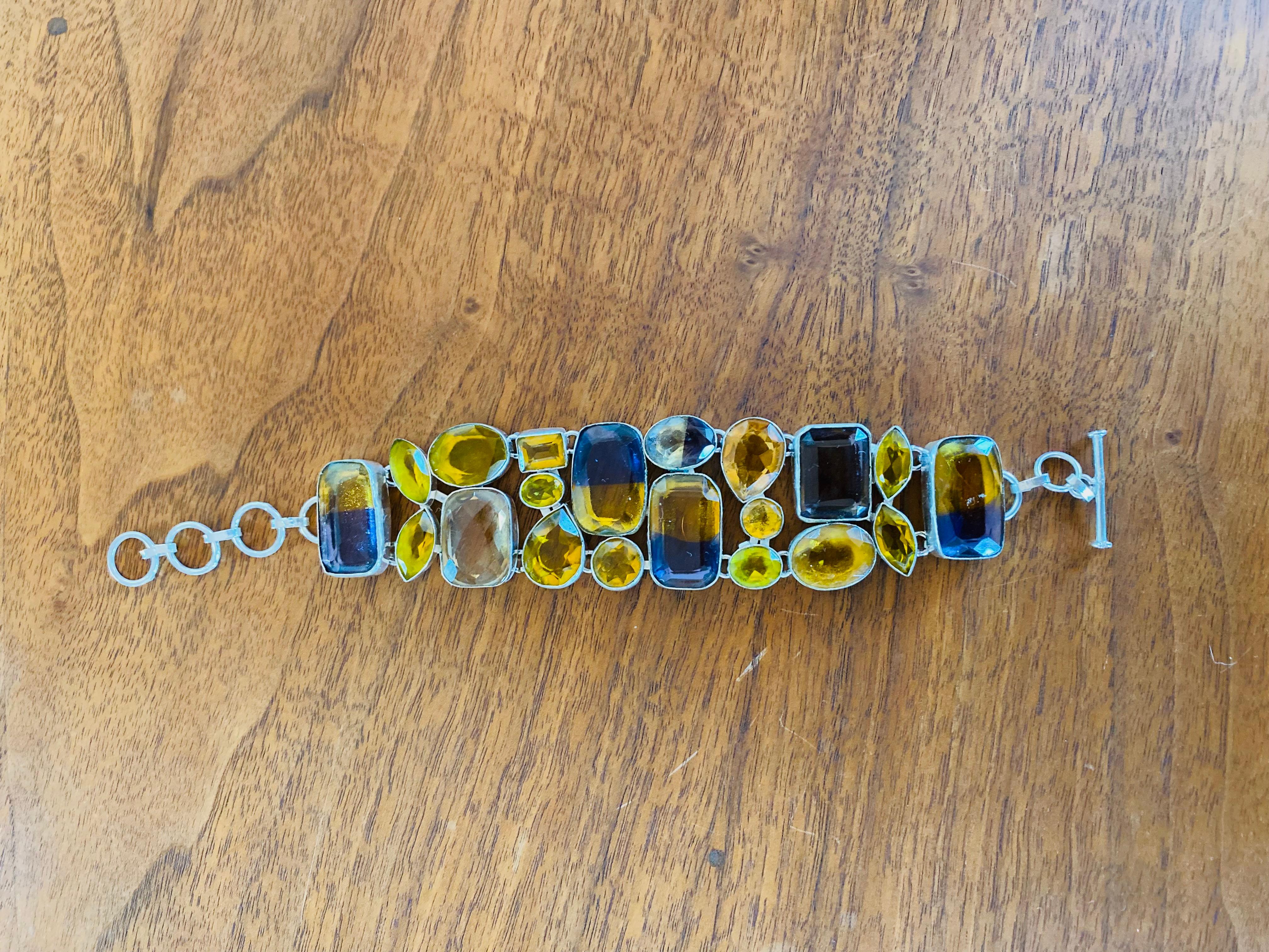 Preciosa pulsera escultórica de piedras semipreciosas elaborada a mano con estructura de plata de ley.  Esta pieza es glamurosa y chic.  Los tonos ámbar del cristal se combinan con el lila creando un efecto deslumbrante a la vez que chic.  Esta