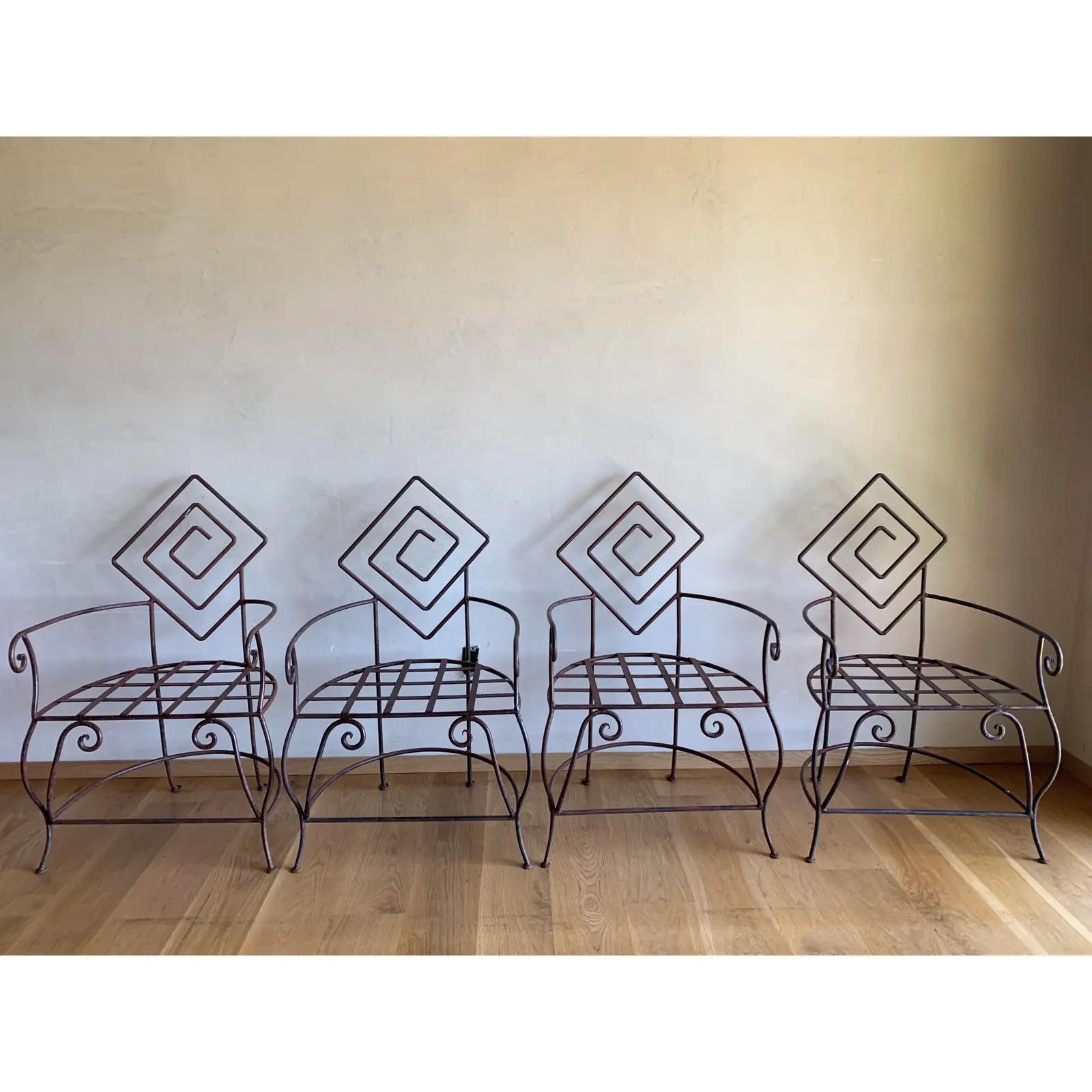 Ensemble de quatre chaises en fer très sculpturales et robustes, fabriquées à la main par des artisans, avec des accoudoirs et des pieds biomorphiques larges et courbés, culminant dans des dossiers géométriques en forme de labyrinthe.
Des pièces