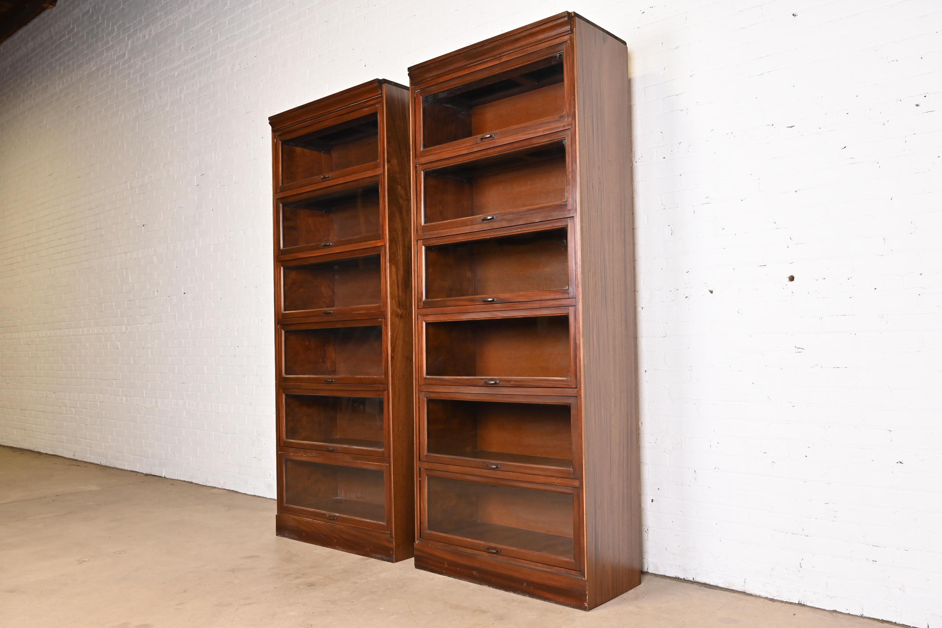 A gorgeous pair of vintage Arts & Crafts large six-stack barrister bookcases

In the manner of Globe Wernicke

USA, Mid-20th century

Mahogany, with glass front doors and brass hardware.

Measures: 36
