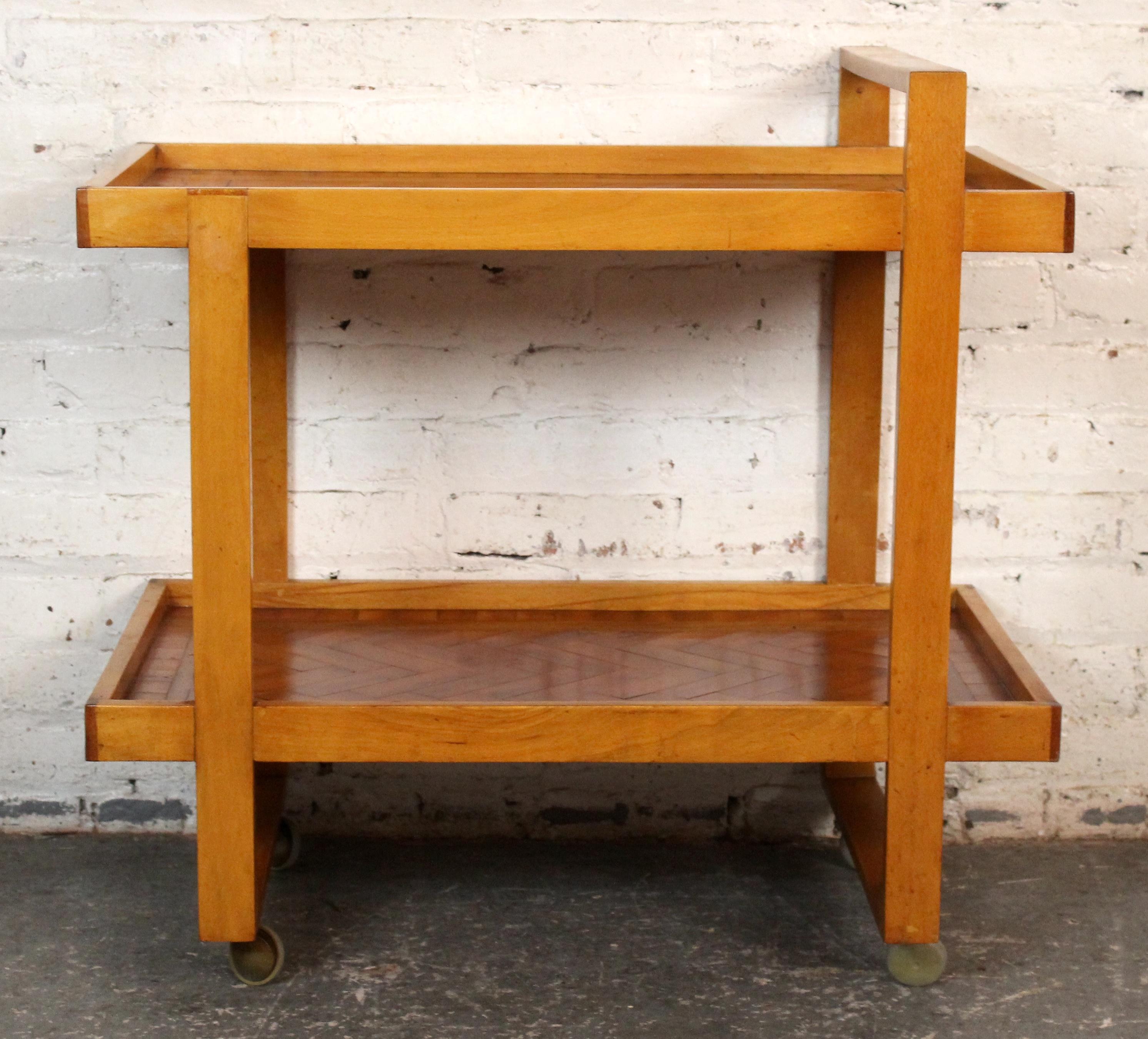 Vintage oak parquet bar cart featuring rich wood grain and intricate parquetry detail. This mid-century gem offers timeless elegance with two-tier shelving, smooth-rolling casters, and sculptural lines—perfect for serving in style or displaying your