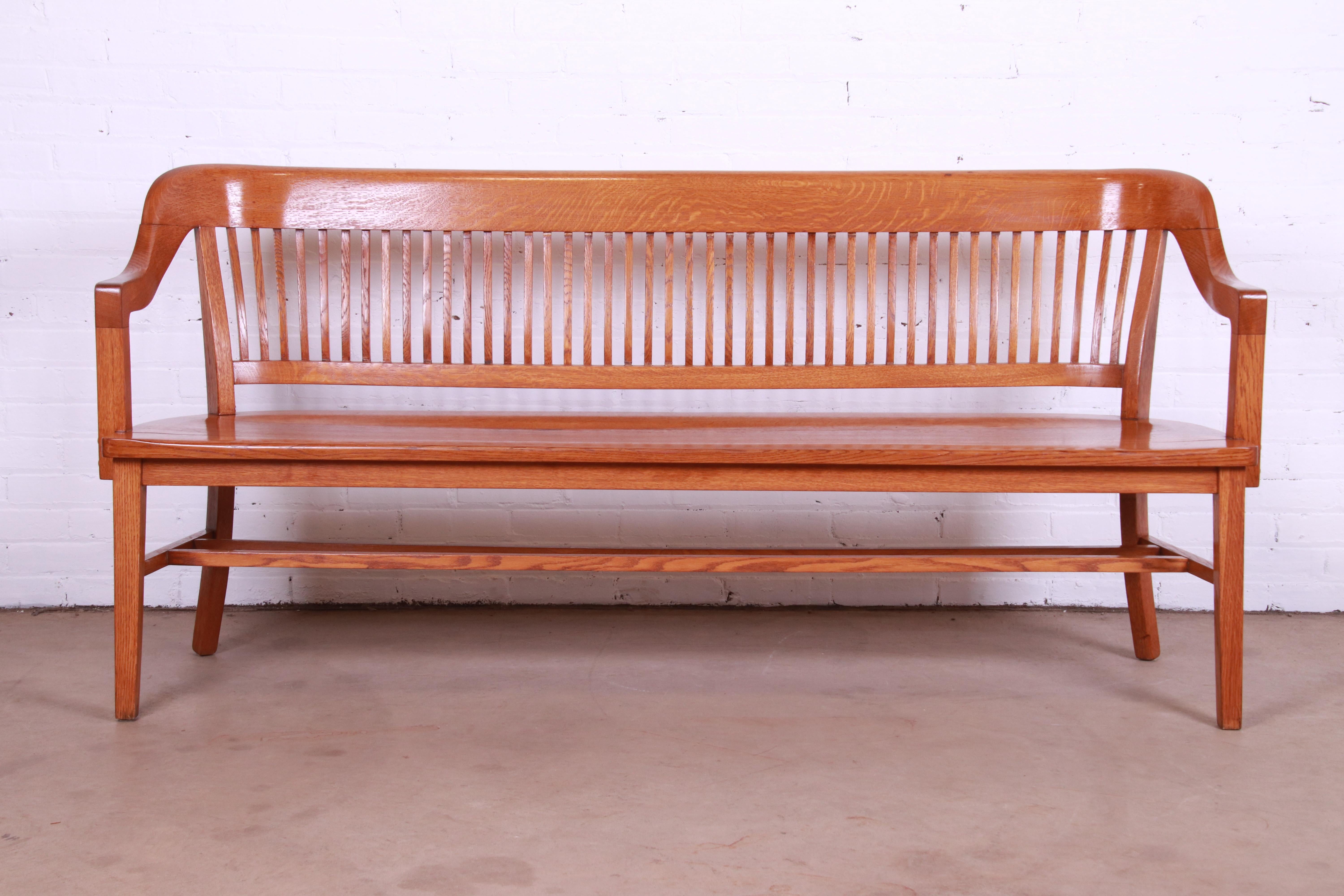 An exceptional Arts & Crafts style solid oak spindle back banker or lawyer bench

USA, Circa 1940s

Measures: 72