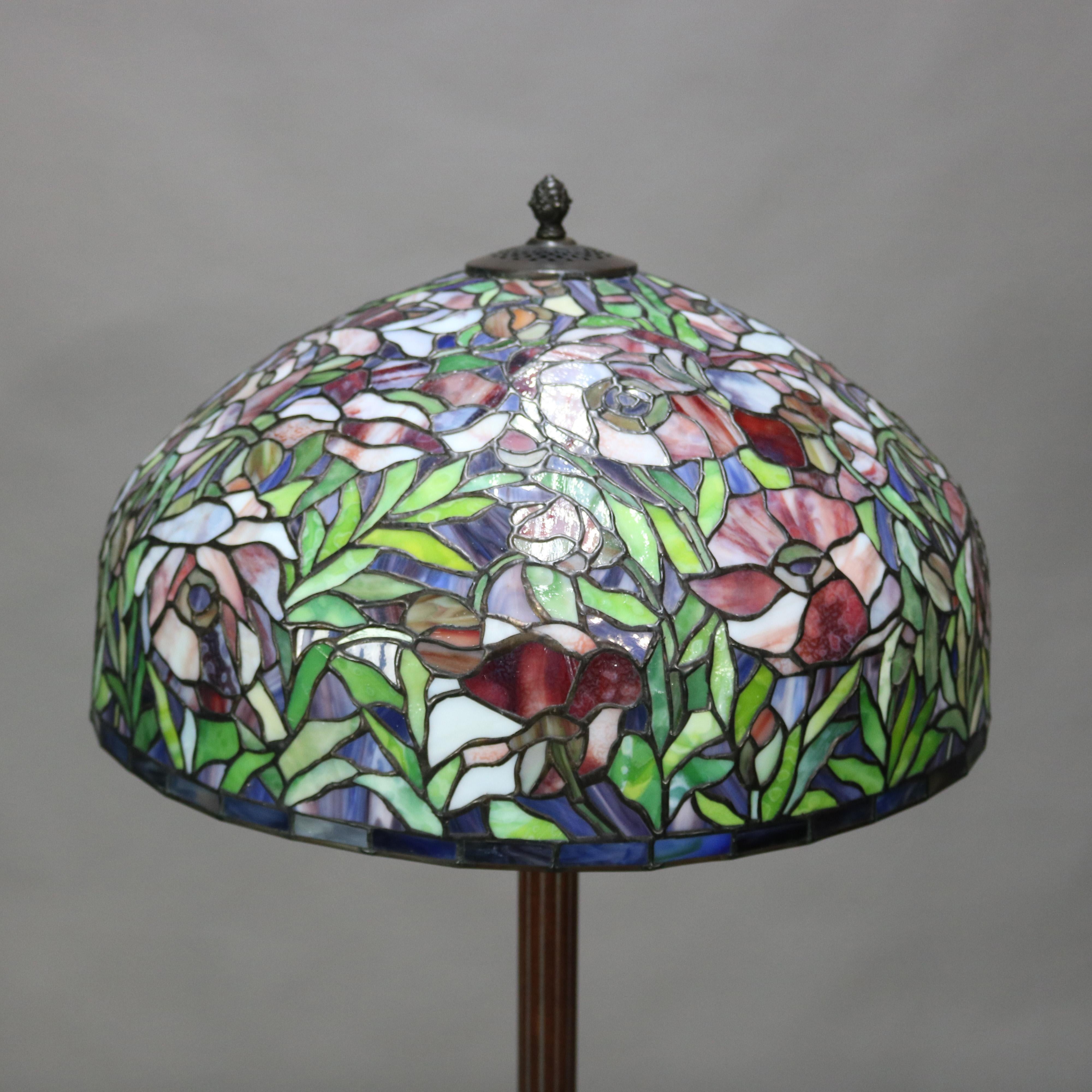 A vintage Arts & Crafts Tiffany Studios style mosaic floor lamp offers dome form leaded stained glass shade with floral design surmounting triple socket cast metal base raised on tripod stylized paw feet, 20th century

***DELIVERY NOTICE – Due to
