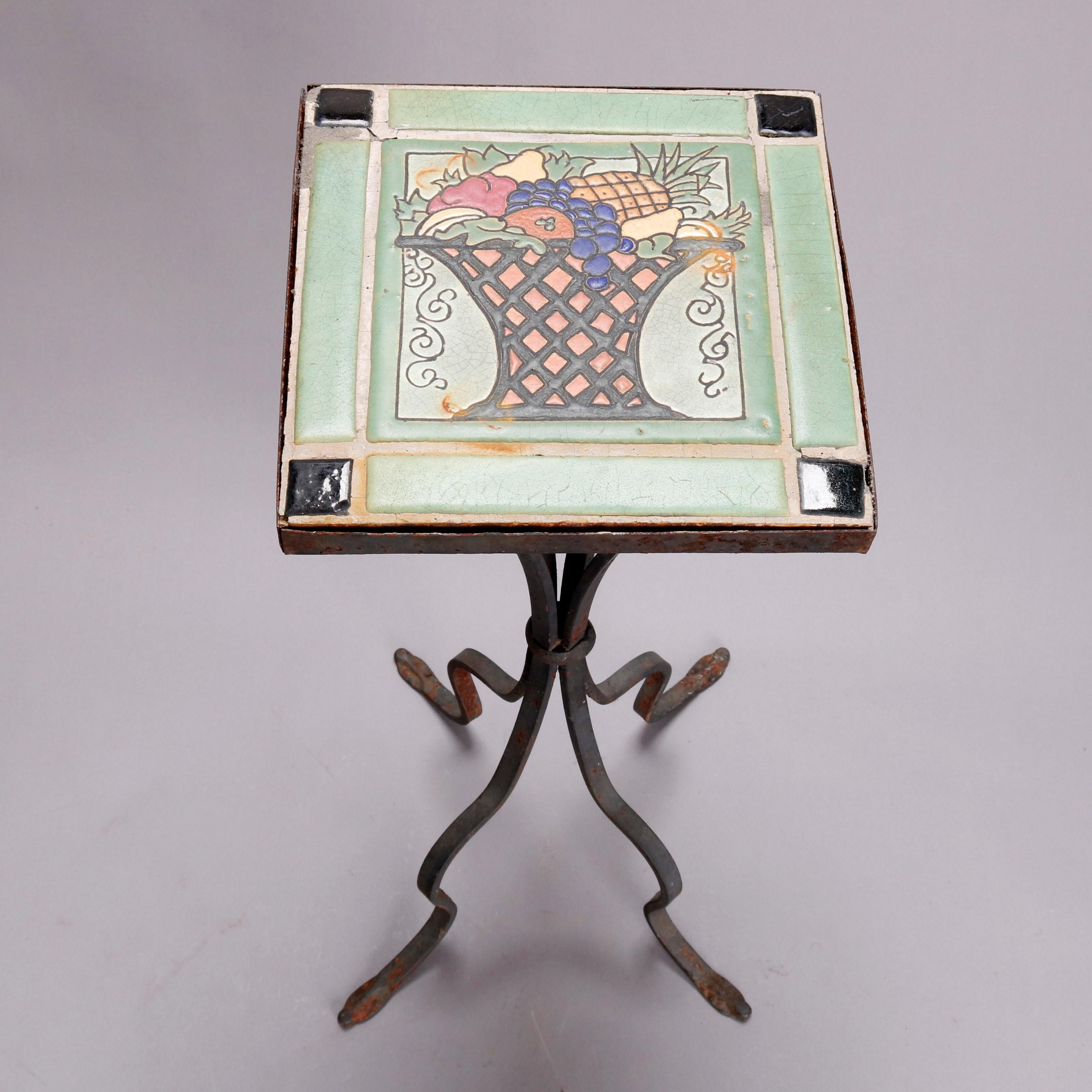 A vintage Arts & Crafts Yellin School tile top side stand offers enameled ceramic tile with panier de fleurs within frame having ebonized corners and surmounting wrought iron stand with four concave legs with central band and terminating in cabriole