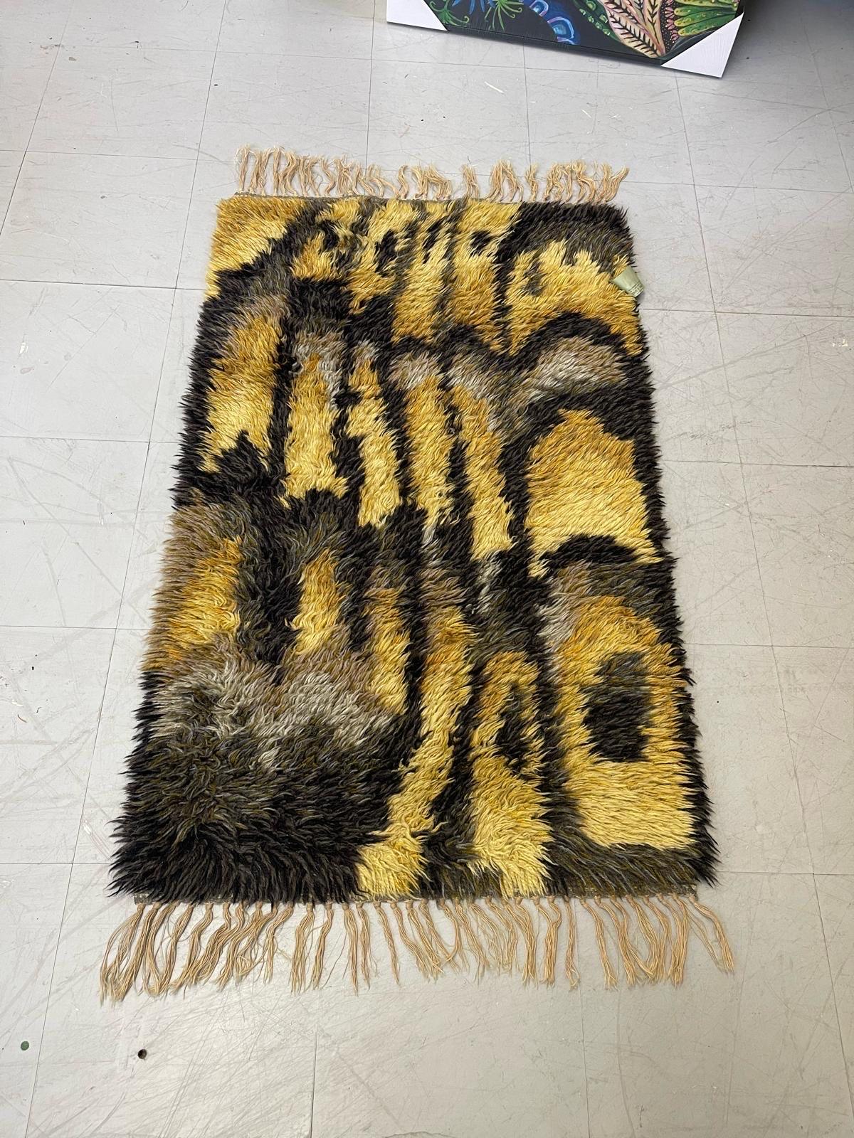 This Vintage Piece is in the Style of Rya Rugs, a Scandinavian Mid Century Company. The Tag Attached is from a Previous Rug Cleaning. This Rug has Tassels on the Two Shorter Sides. Vintage Condition Consistent with Age as Pictured.

Dimensions. 38 L