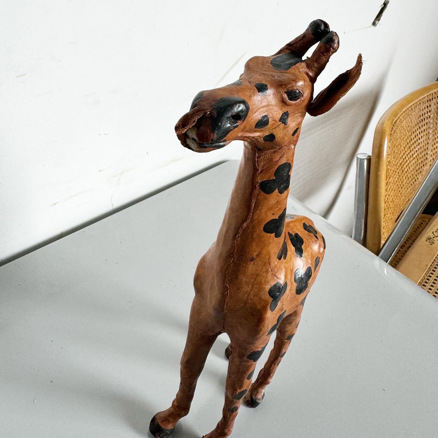 Élevez votre décor avec cet ensemble exquis de trois sculptures de girafes vintage ascendantes enveloppées de cuir. Chaque pièce est enveloppée avec art dans du cuir, mettant en valeur les textures et les teintes naturelles. Les sculptures, de