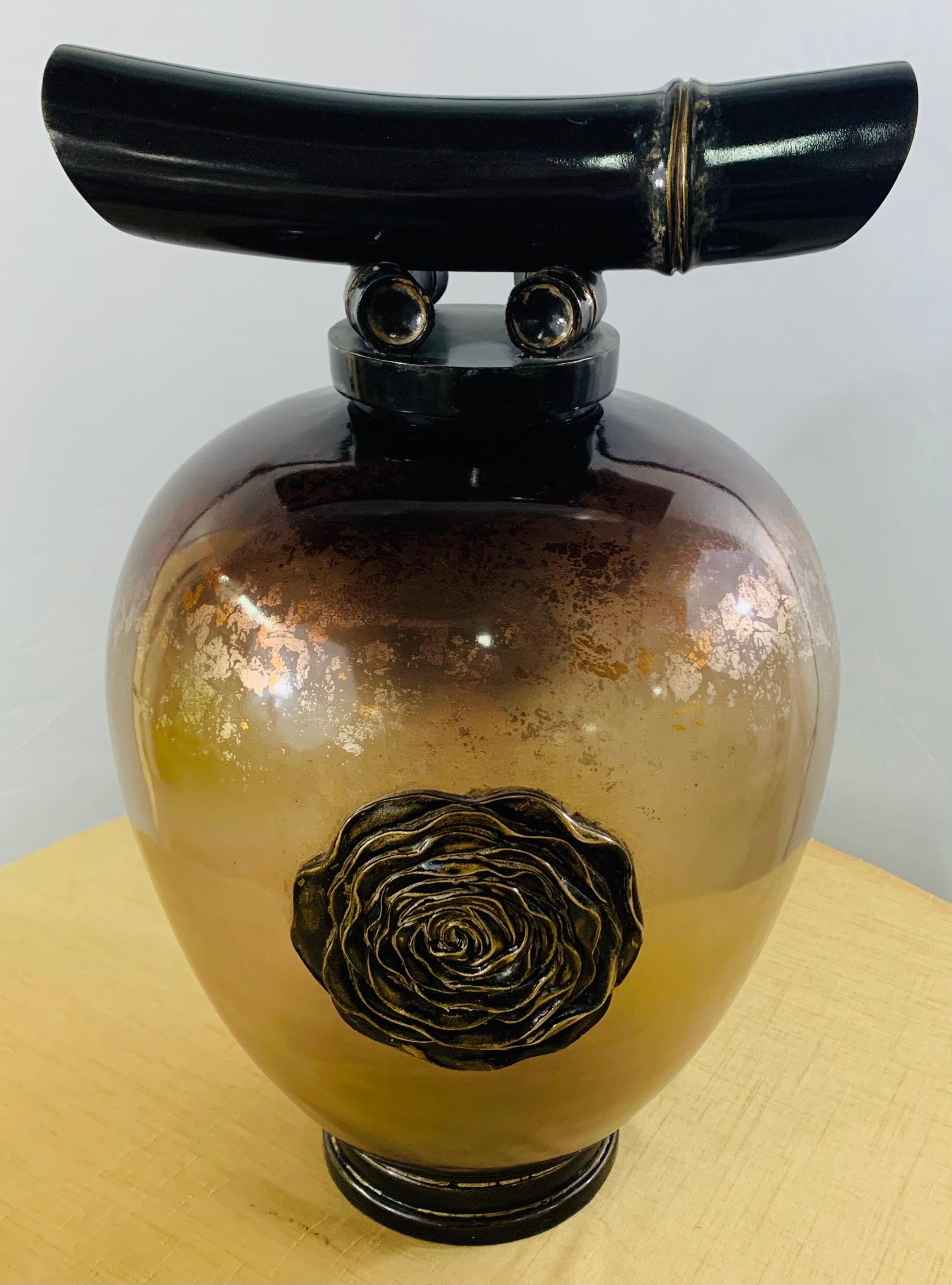 A highly decorative vintage Asian amber glass vase or lid urn. The urn features a handcrafted flower brass design in the center of the vase, a round wooden base in black and gilt decorated. The lid of the urn is in the shape of a sword holder or