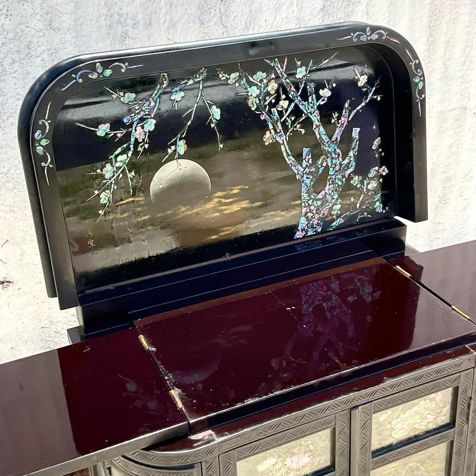 Vintage mid 20th century inlaid and black lacquered drinks cabinet. Done in the manner of a George Zee. Beautiful vintage mirrored glass interior with a flip top bar for extra surface space. Acquired from a Palm Beach estate.