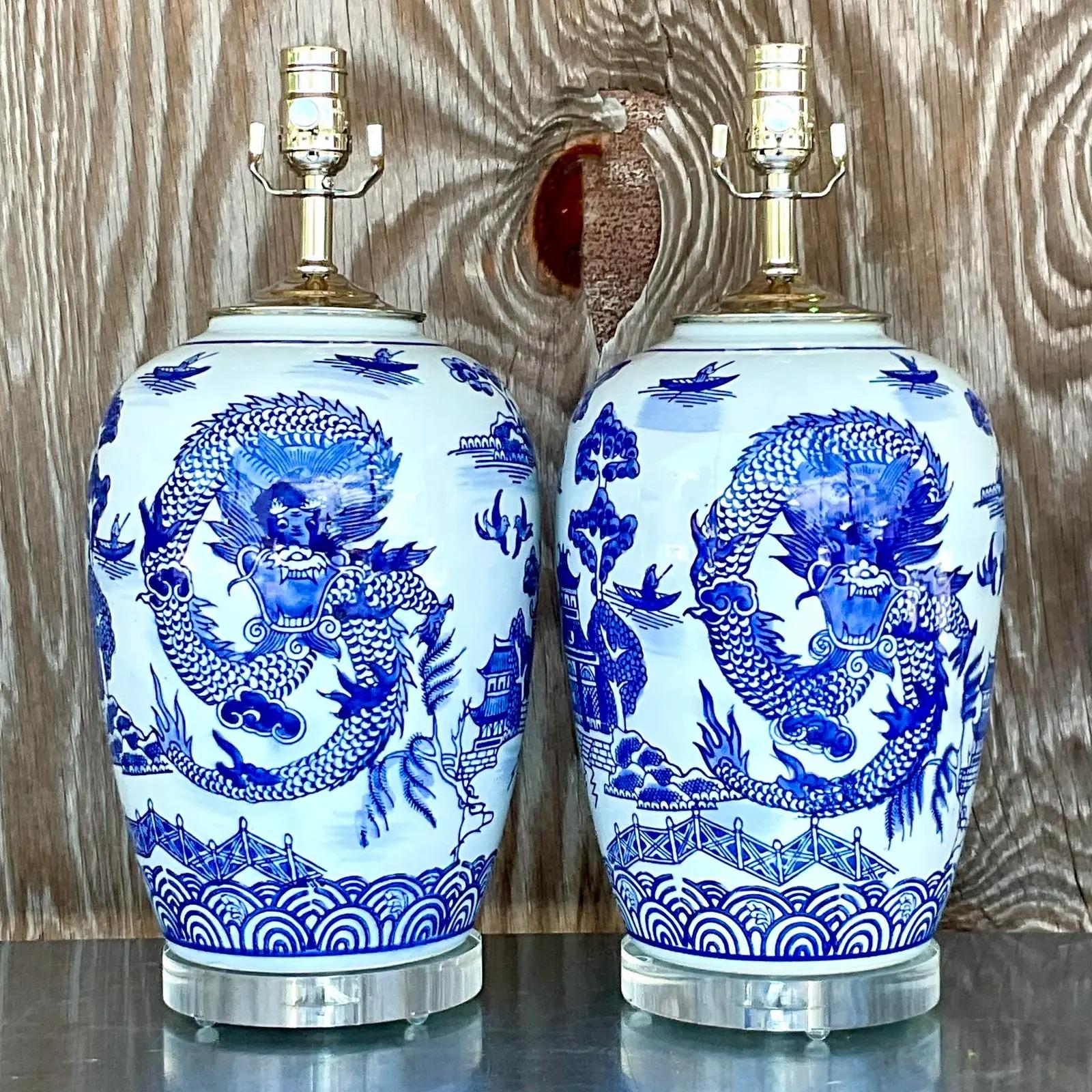 Fantastic vintage Asian table lamps. Beautiful blue and white design with a chic dragon circling the lamps. Fully restored with all new hardware and wiring. Acquired from a Palm Beach estate.