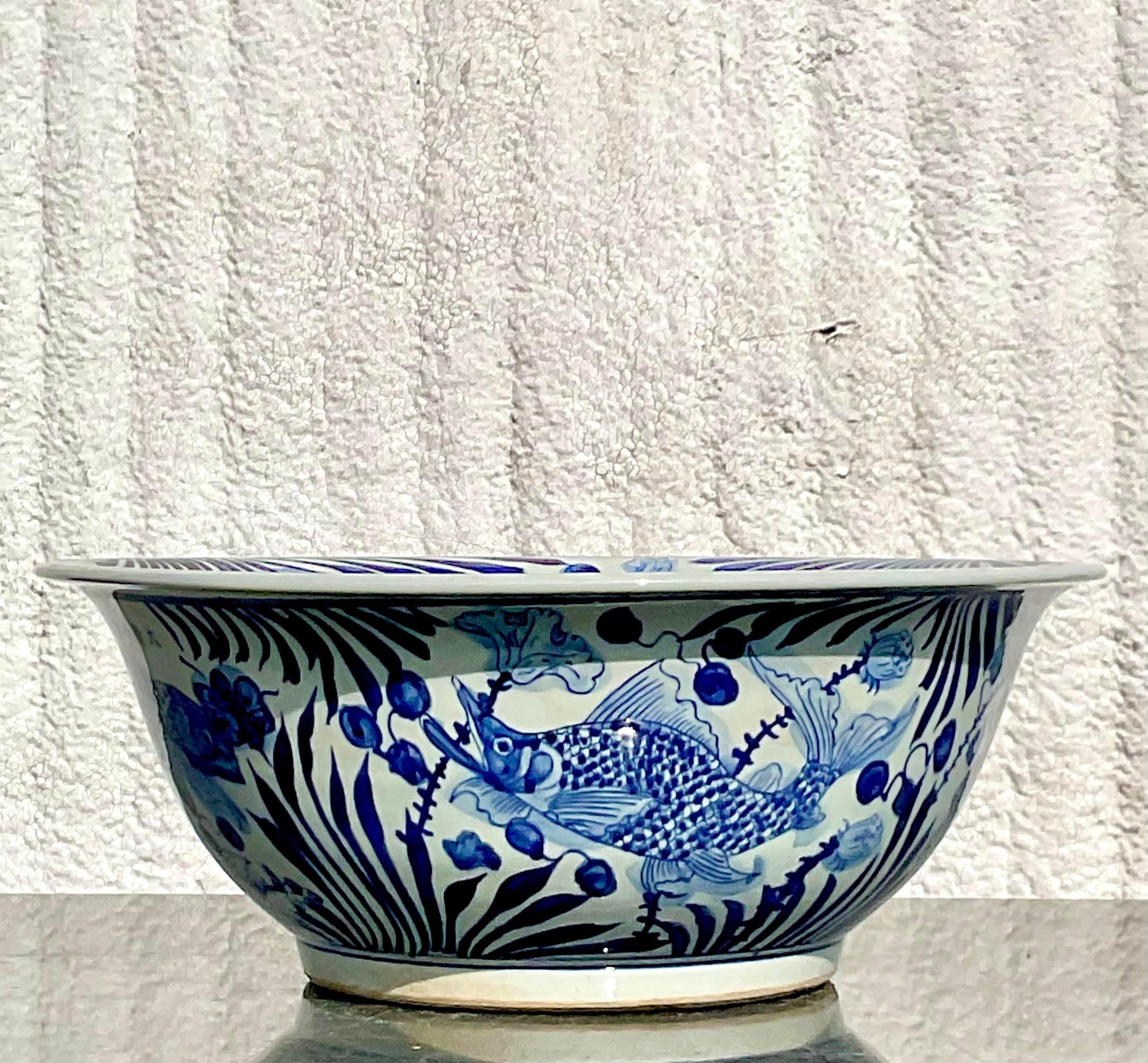 A fabulous vintage Asian centerpiece bowl. A chic fish design in a classic blue and white story. A chic glazed ceramic finish. Perfect alone or fill it it with shells or orchids. You decide! Monumental in size and drama. Acquired from a Palm Beach
