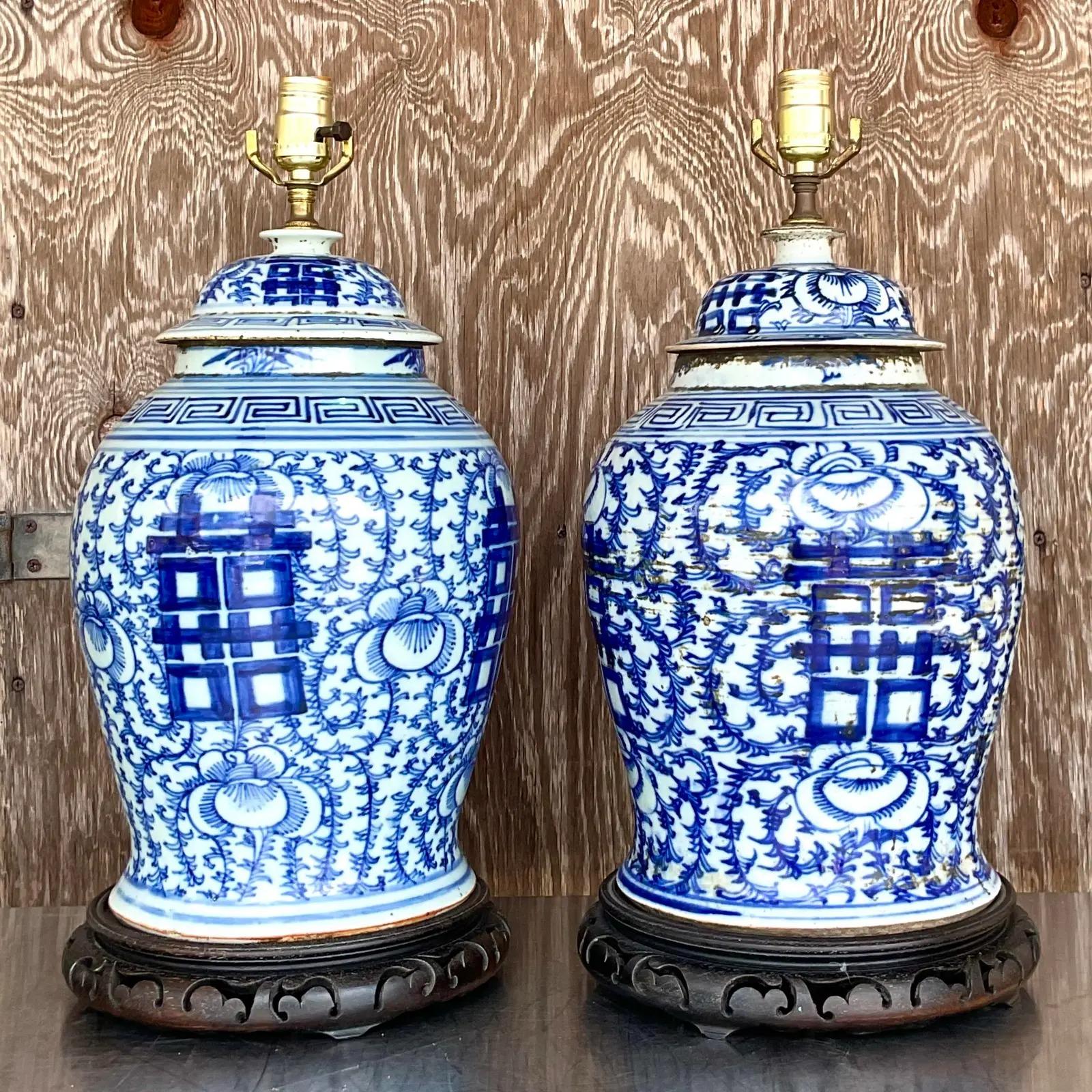 Incredible pair of vintage Asian table lamps. Beautiful iconic blue and white on thick glazed pottery. Done on the classic ginger jar shape with carved plinths. Acquired from a Palm Beach estate.

The lamps are in great vintage condition. Minor