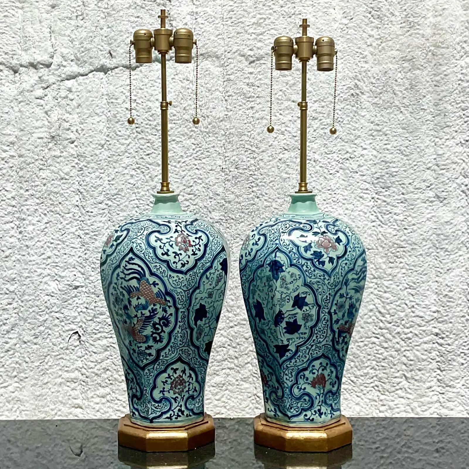 An amazing pair of vintage Asian table lamps. Beautiful and iconic blue and white design with small flashes of pale pink. Tall brushed brass hardware with a double socket. Acquired from a Palm Beach estate.