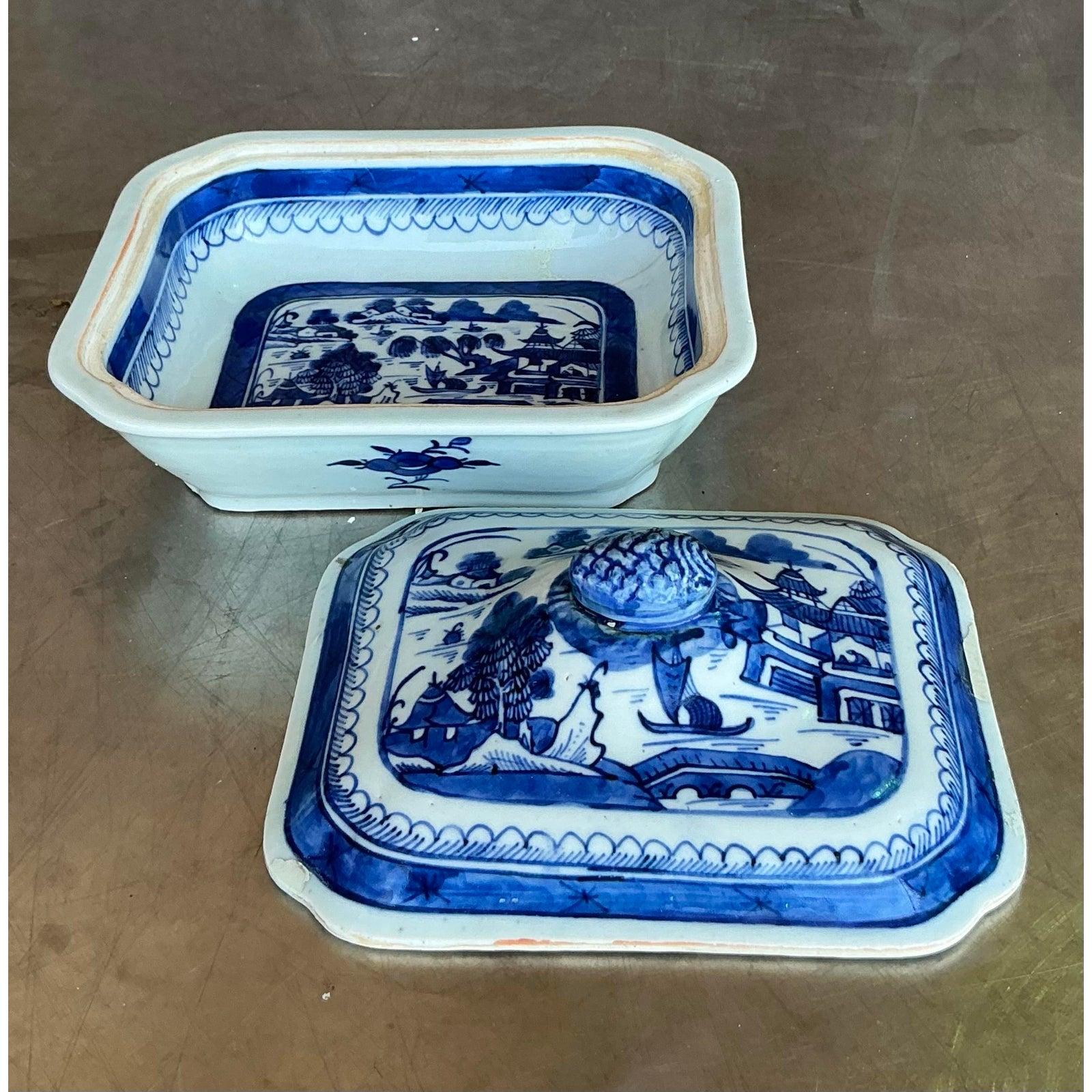 Élevez votre présentation de table avec cet élégant plat de service asiatique vintage bleu et blanc à couvercle. Le couvercle est surmonté d'un fleuron sculpté et encadré d'une bande décorative traditionnelle. Il présente un paysage pittoresque dans