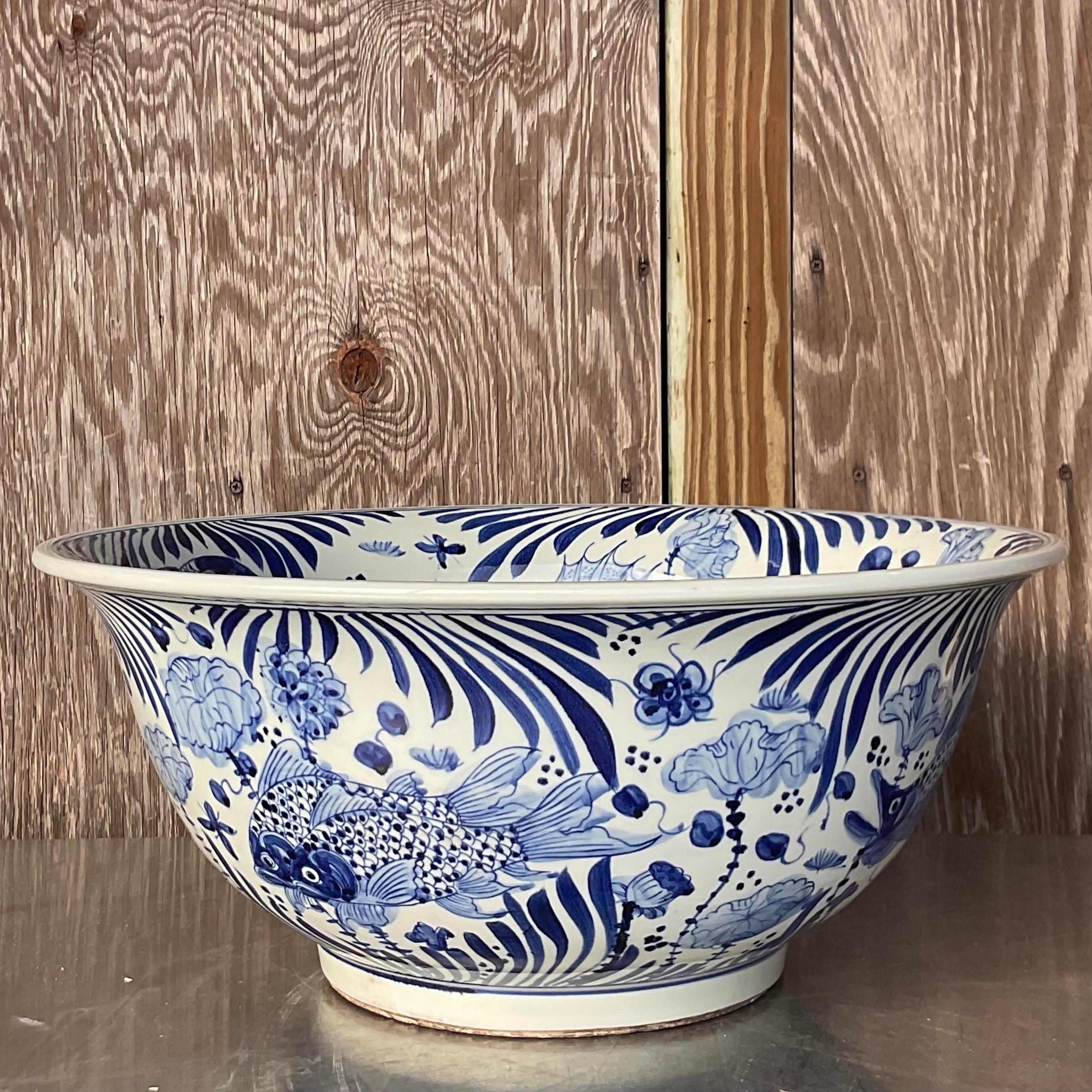 An absolutely stunning vintage white ceramic bowl with blue detailing painted on it. The bowls interior is painted with a beautiful oceanic scenery and creatures. Acquired at a Palm Beach estate. 
