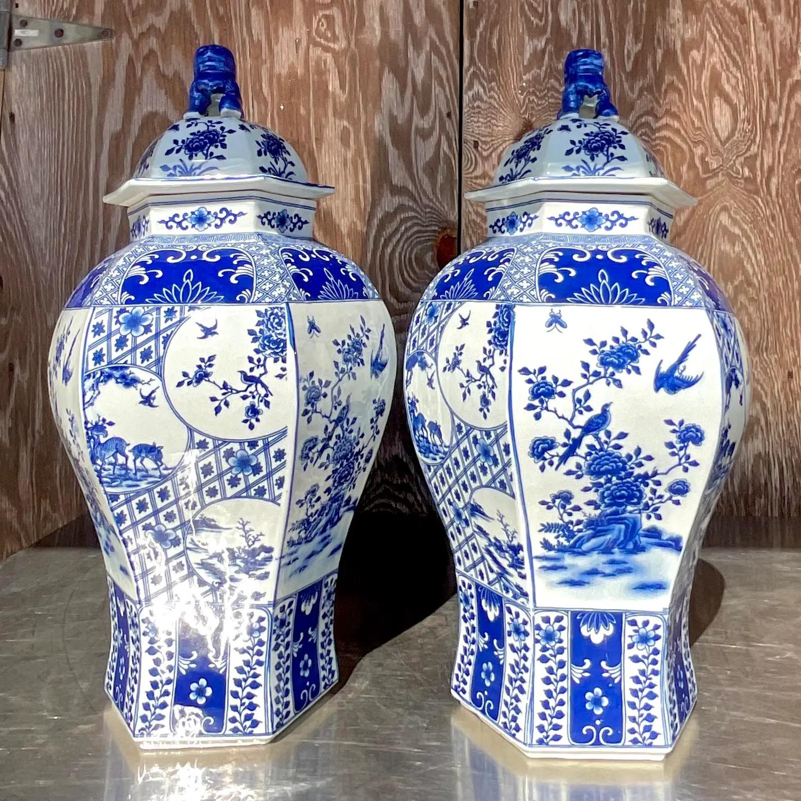A fabulous pair of vintage Asian tall lidded urns. Beautiful iconic trellis design with love birds and flowers. Large and impressive. Acquired from a Palm Beach estate.