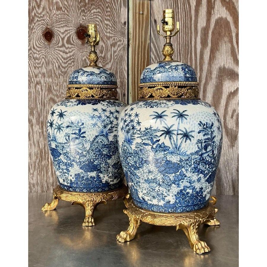 These exquisite lamps feature a harmonious blend of gleaming brass bases and intricately designed ceramic bodies, showcasing traditional Asian motifs with timeless elegance. The rich detailing and vibrant colors on the ceramic create a striking