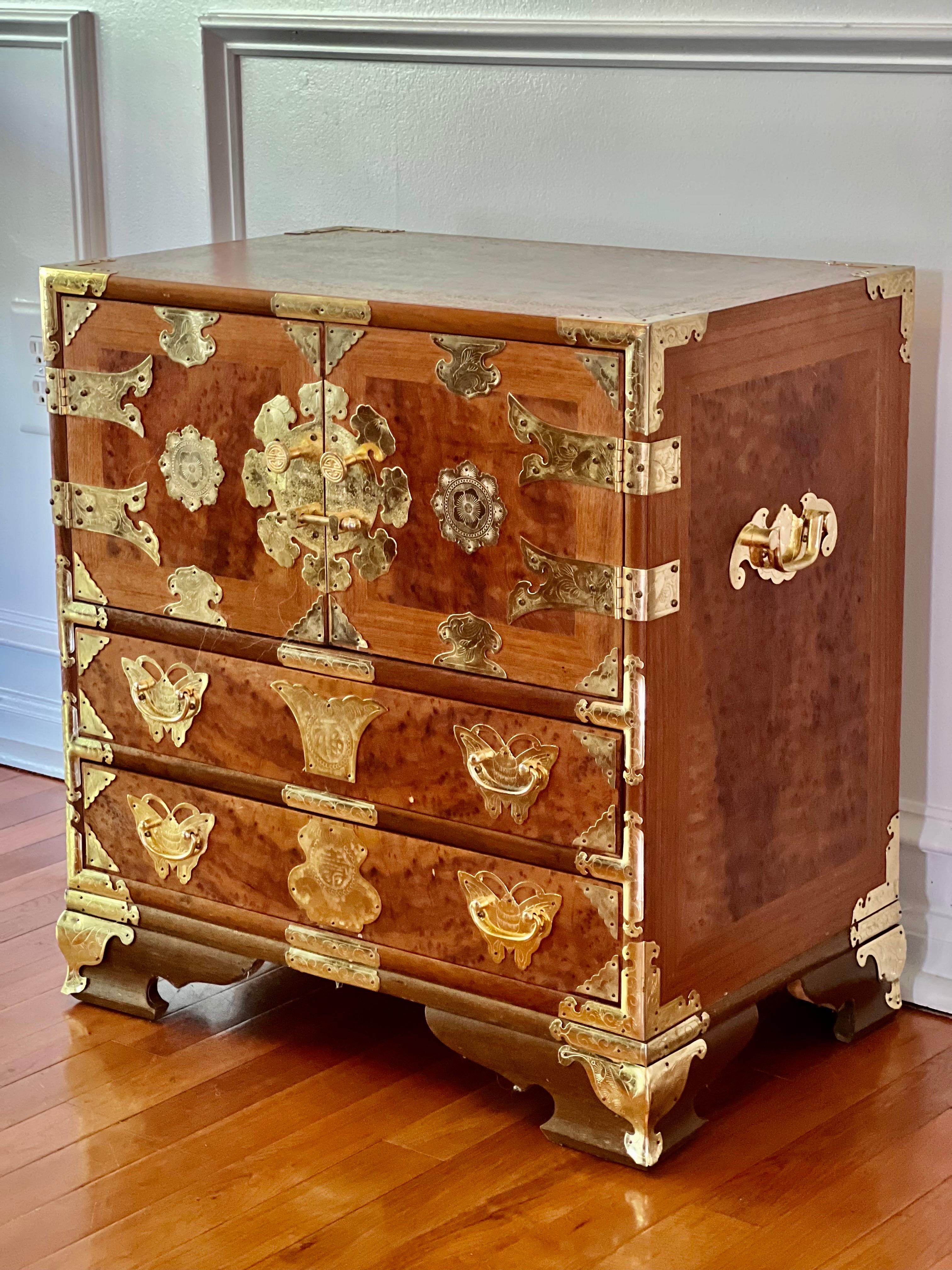 Beautiful Korean Camphorwood burl Bandaji style chest, c. 1960's. 

The chest features two internal small drawers and two full size lower drawers lined with red velvet. Gorgeous, oversized floral etched brass hardware adorn the piece throughout and