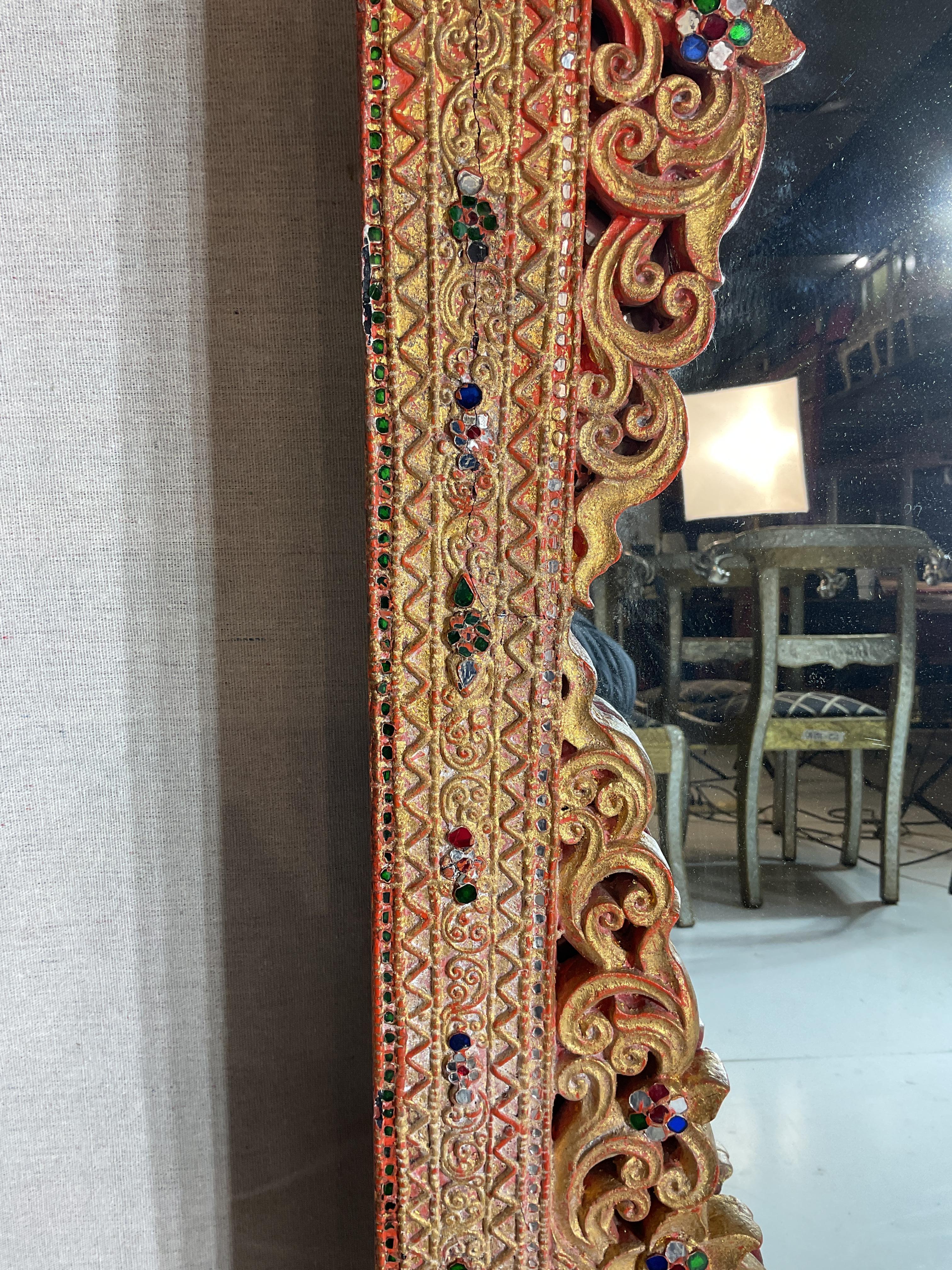 Miroir mural en bois très original
Bois peint et doré avec des détails sculptés complexes et de magnifiques bijoux et miroirs. 
Fabriqué en Asie au milieu du 20e siècle 
