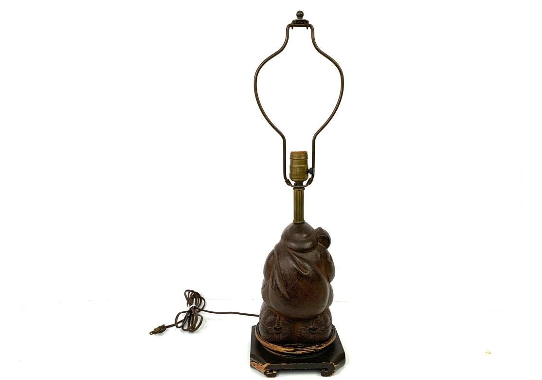 Lampada da tavolo con statua in ghisa di Daikokuten, il dio giapponese della ricchezza e della fortuna. La figura corpulenta in ghisa è seduta in cima a due sacchi e tiene in mano un maglio magico.
Daikokuten è una delle sette divinità fortunate