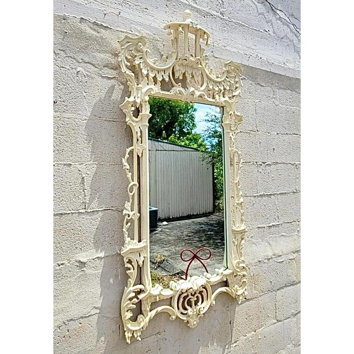 Fantastic vintage Chinoiserie mirror. A classic pagoda shape with hand carved detail and four small bells across the roofline. Acquired from a Palm Beach estate.