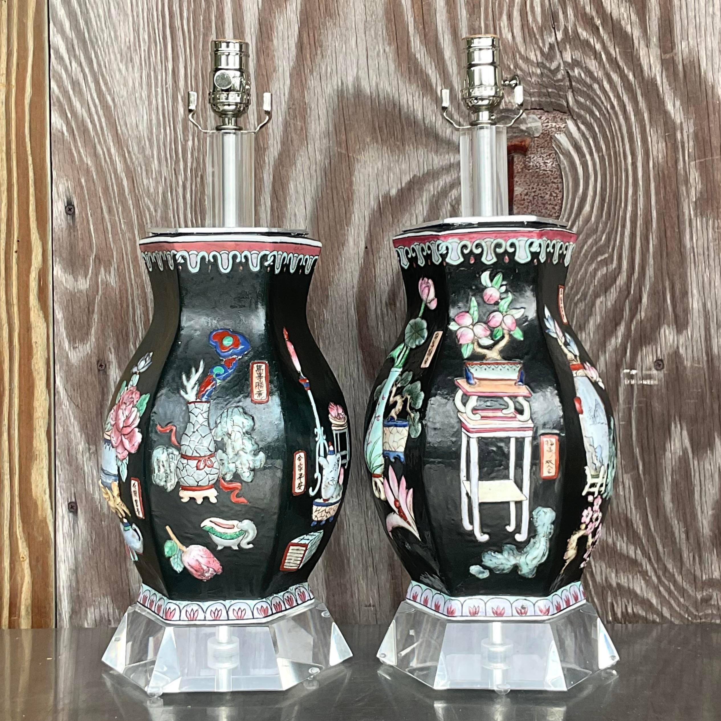 A fabulous pair of vintage table lamps. A chic Chinoiserie relief on a matte black background. A faceted lucite plinth adds to the drama. Acquired from a Palm Beach estate