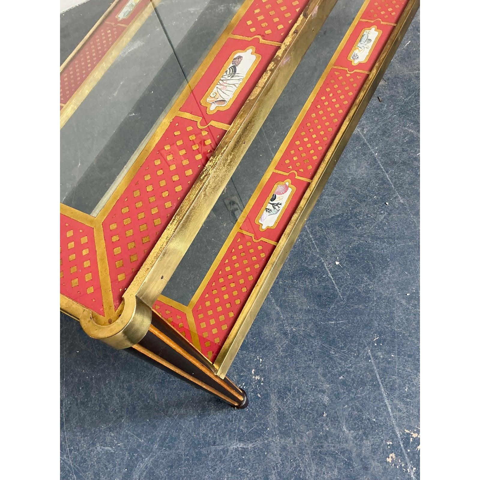 Capture the essence of classic Hollywood glamour with this exquisite two-tier coffee table. The piece is masterfully constructed with a polished brass frame, showcasing clean lines and tapered legs that exude a refined, Neoclassical sensibility. Its