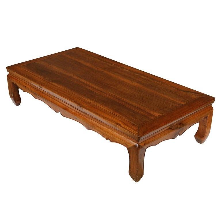 Une super chic et belle table basse asiatique vintage en bois d'orme avec tablier festonné.