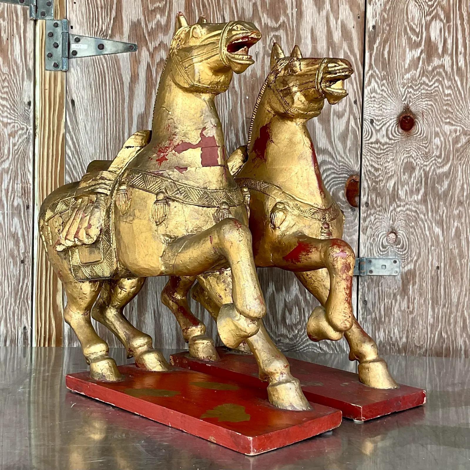 A fantastic pair of vintage Asian Emperor horses. Beautiful carved wood with a gilt finish. Gorgeous all over patina from time. Flashes of the red paint below the gold. Acquired from a palm Beach estate.