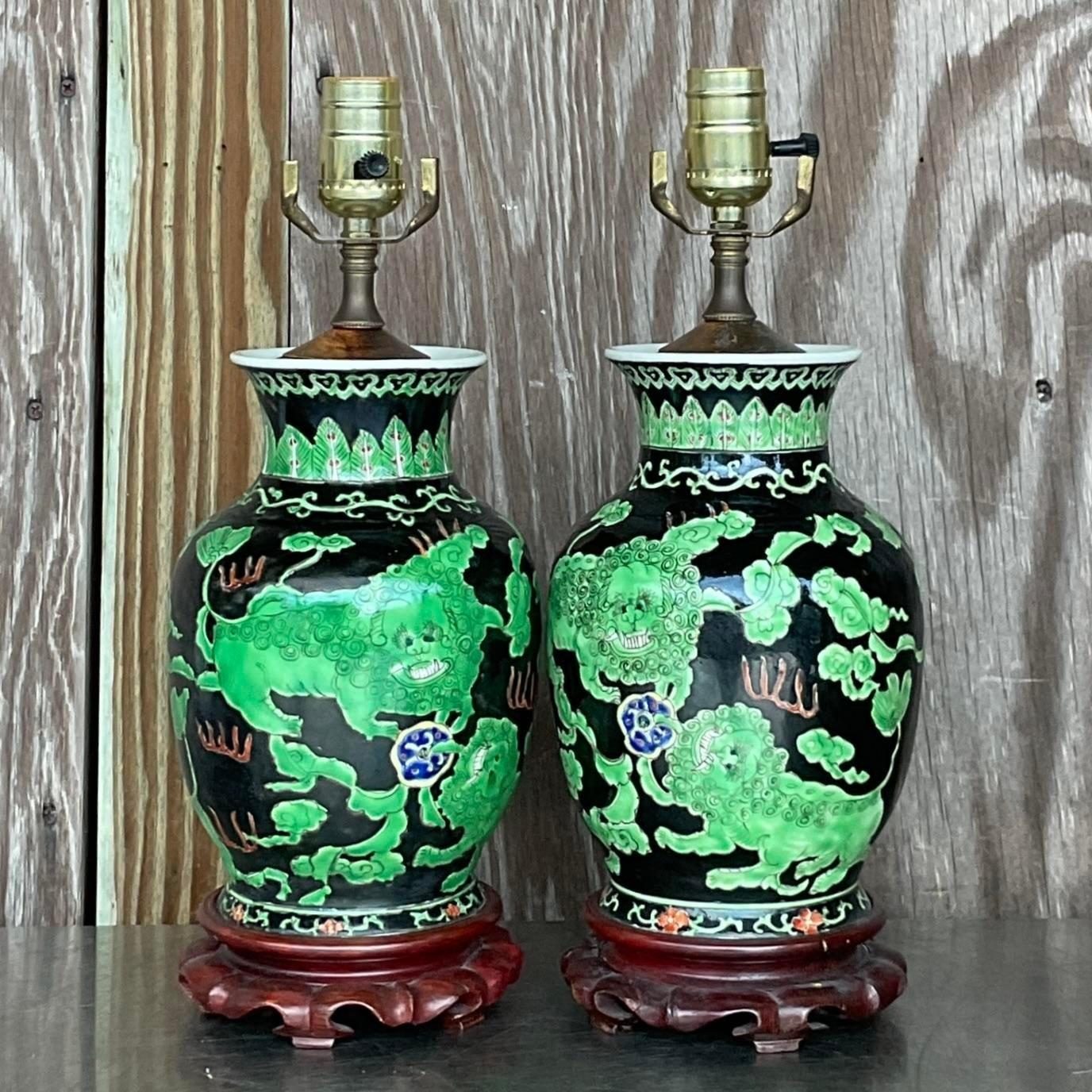 A fabulous pair of vintage Asian table lamps. A classic Ginger jar shape with stunning hand painted scenes with dragons. Brilliantly colored. Acquired from a Palm Beach estate.