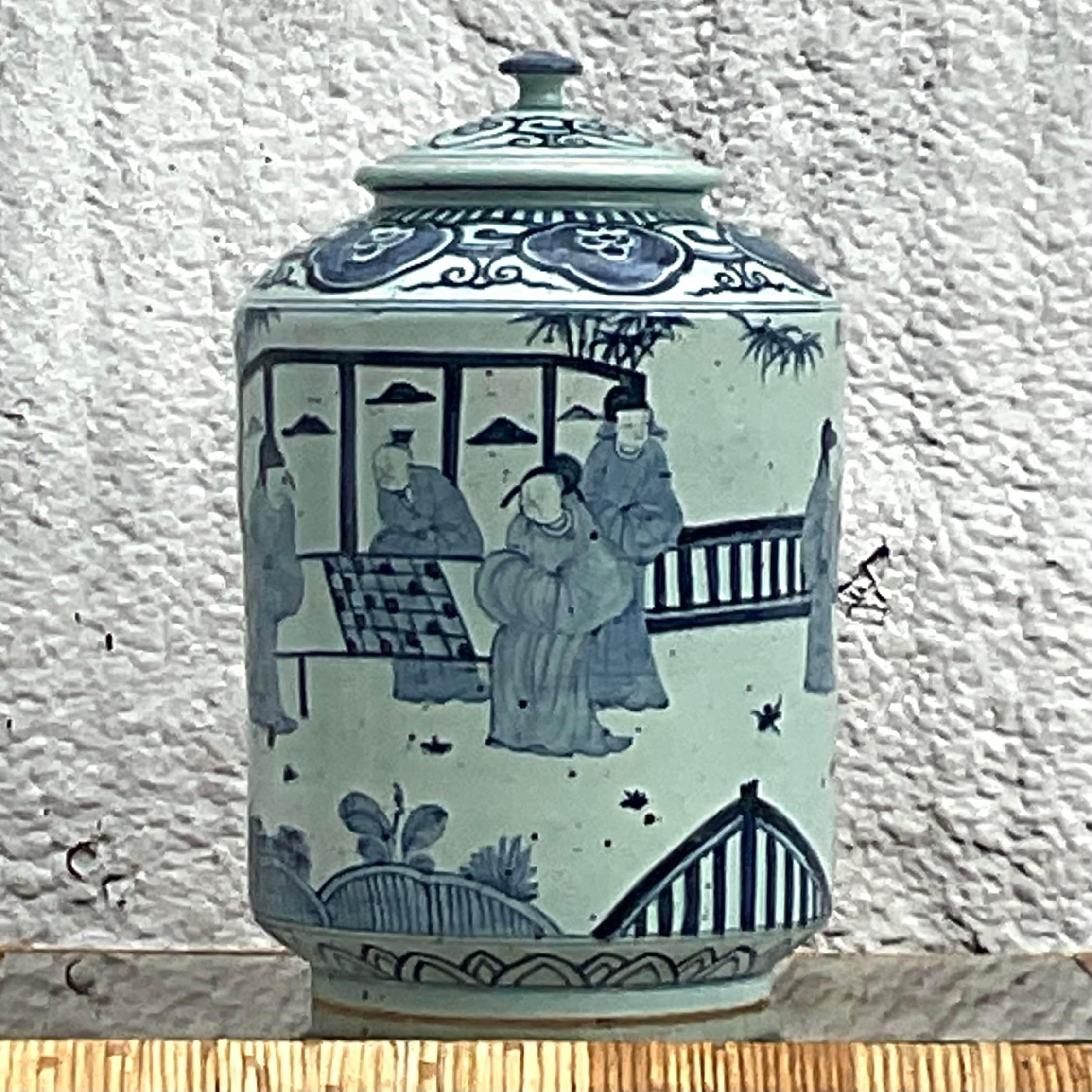 Une superbe urne asiatique vintage à couvercle. Une scène pastorale chic et iconique, peinte à la main en bleu et blanc. Finition en céramique émaillée. Acquis d'une propriété de Palm Beach.